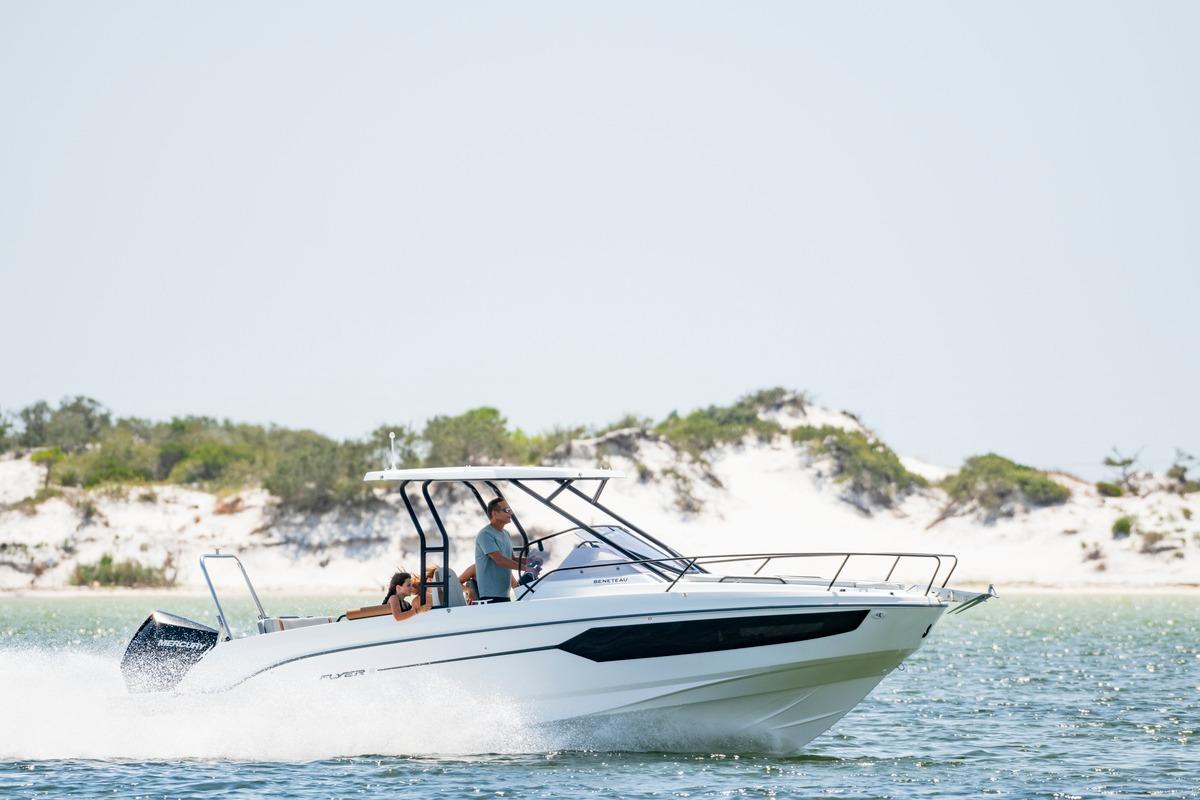 2026 Beneteau Flyer 8 SUNdeck cruising on a sunny day near sandy shoreline.