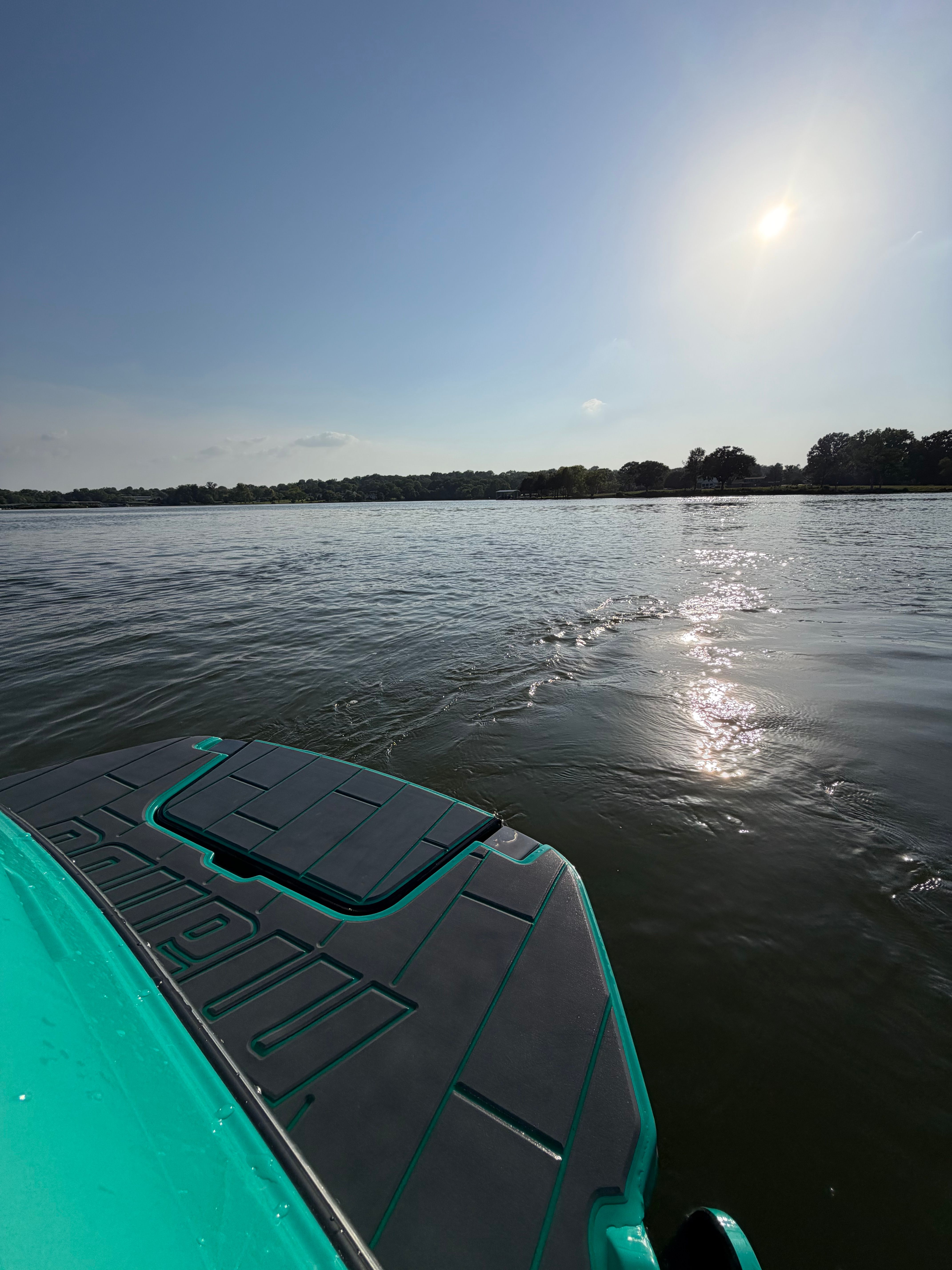 Malibu Wakesetter 24 MXZ on calm water at sunset.