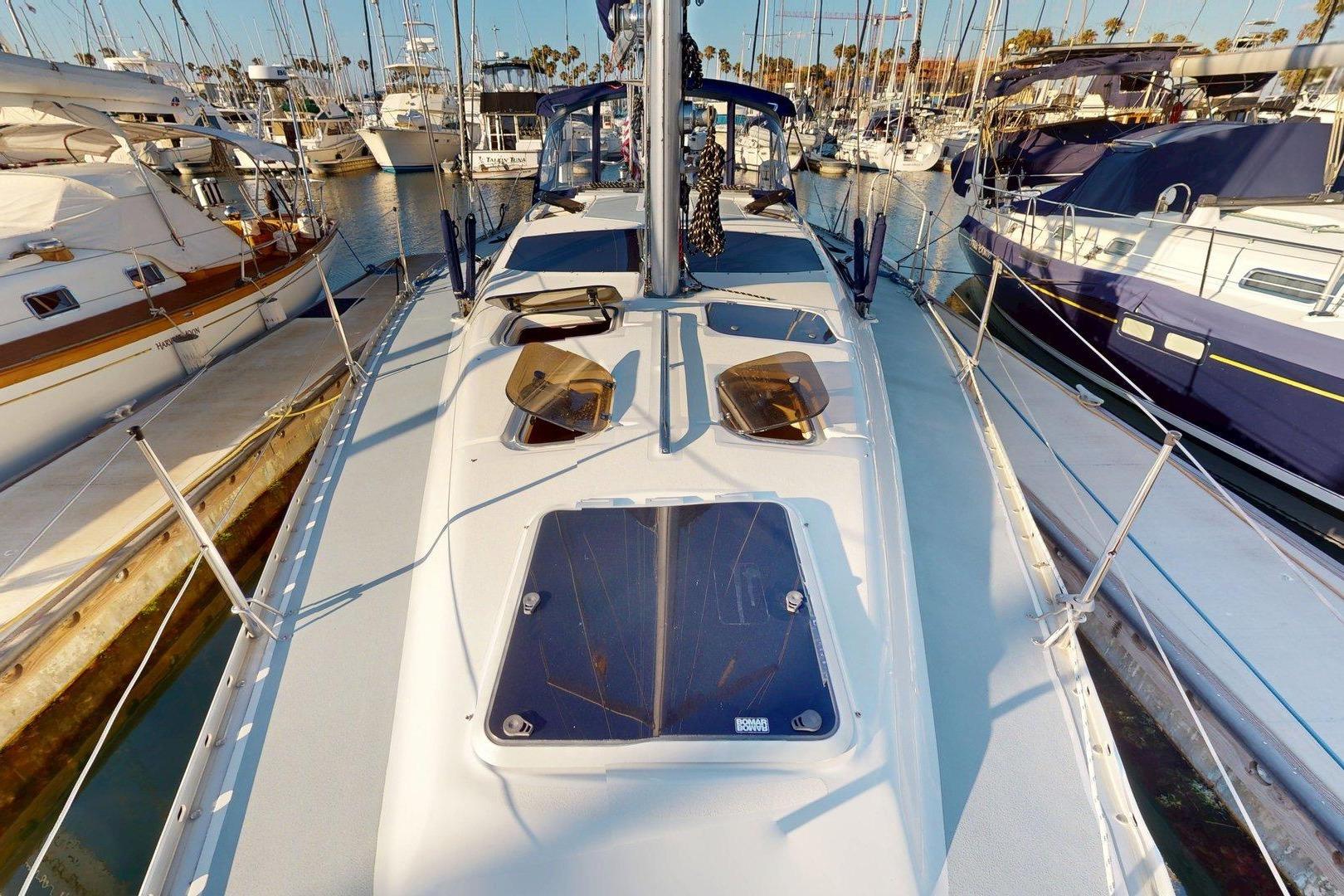 1997 Hunter Legend 40.5 sailboat docked in a marina, surrounded by other boats.