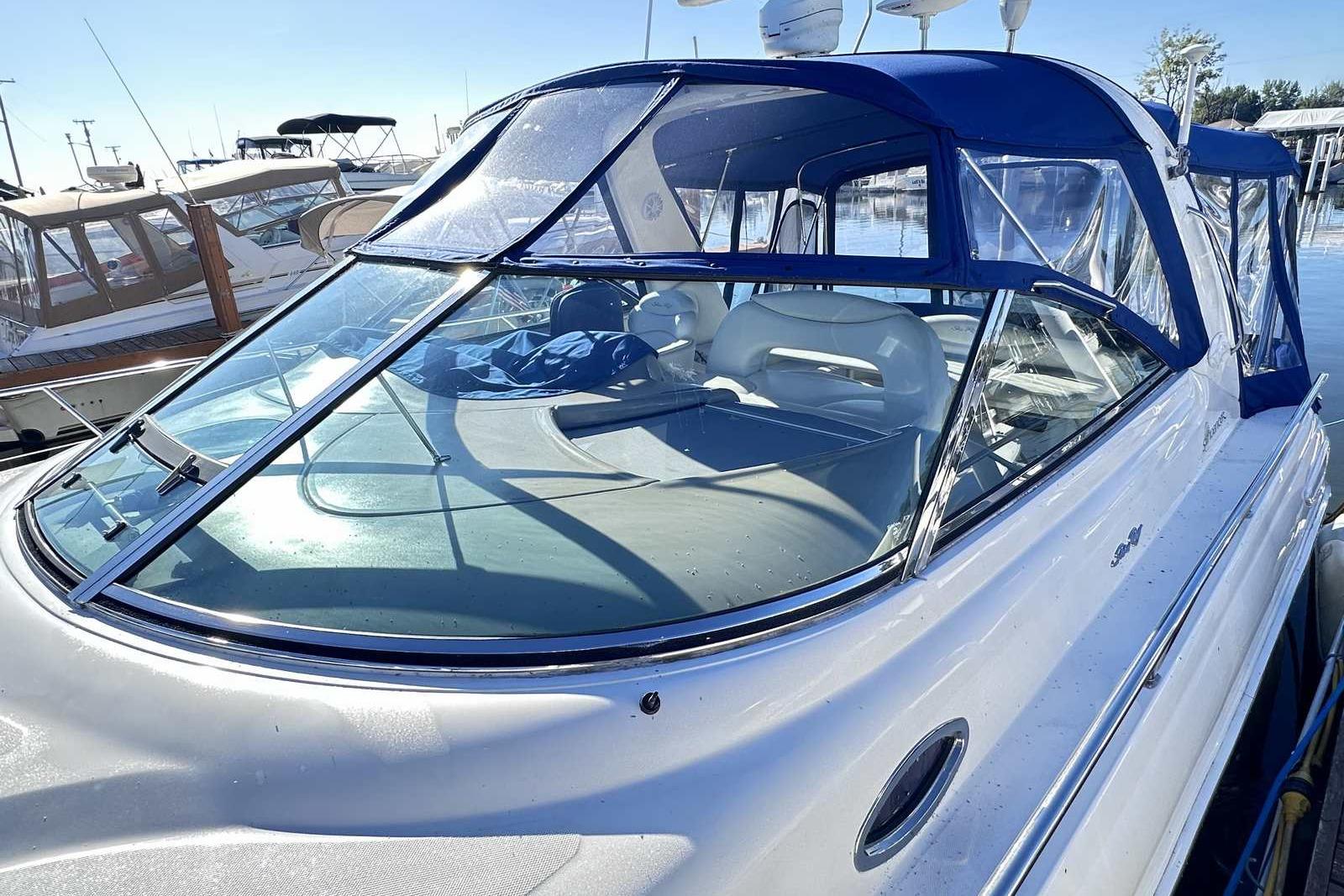 2000 Sea Ray 410 Sundancer yacht with blue canopy docked at marina.