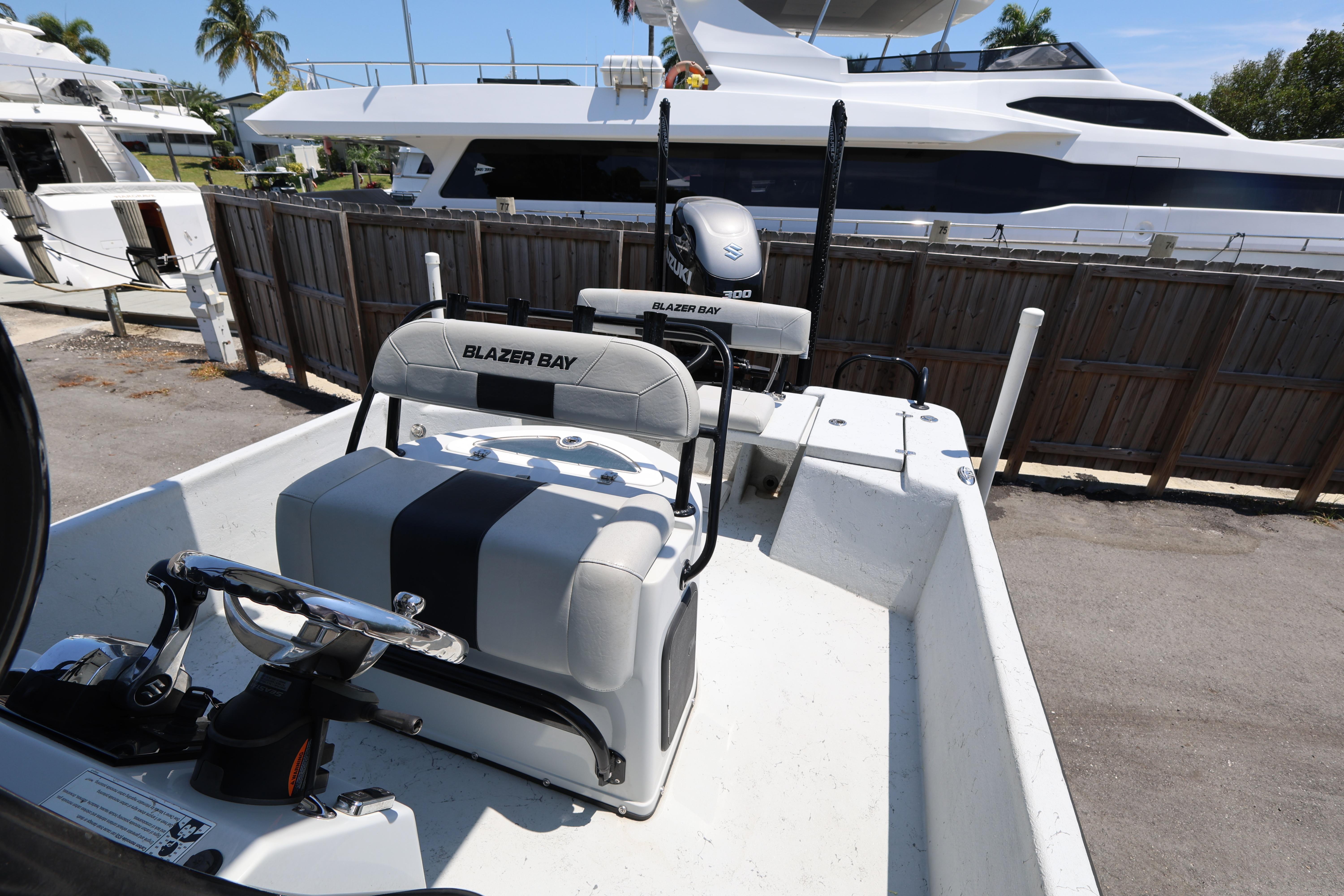 2021 Blazer Bay 2400 boat interior with steering wheel and seating, docked near yachts.