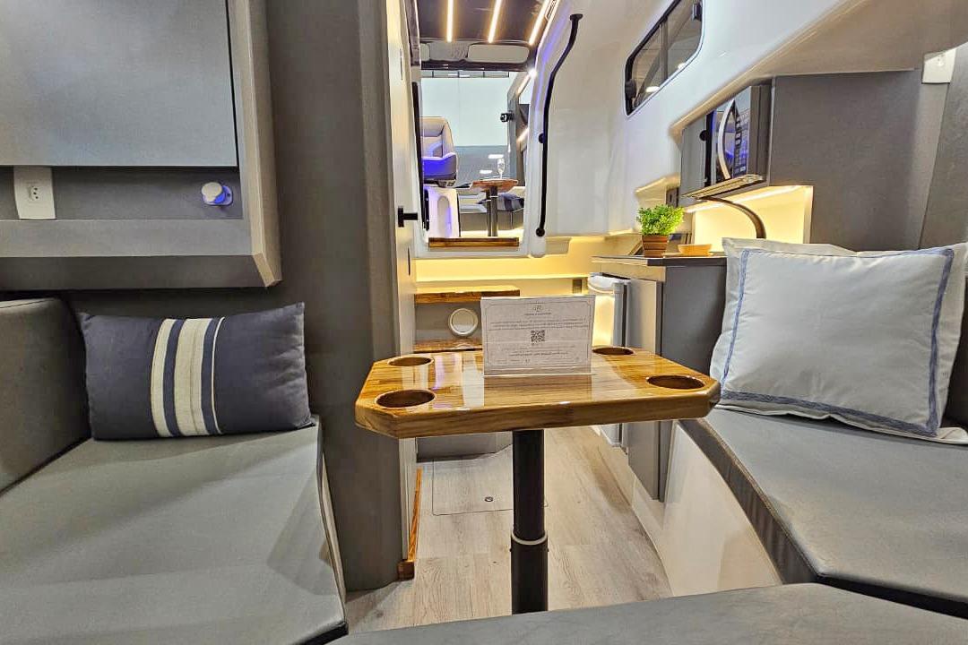Modern interior of 2026 Hanover 327 RV with cozy seating and wooden table.