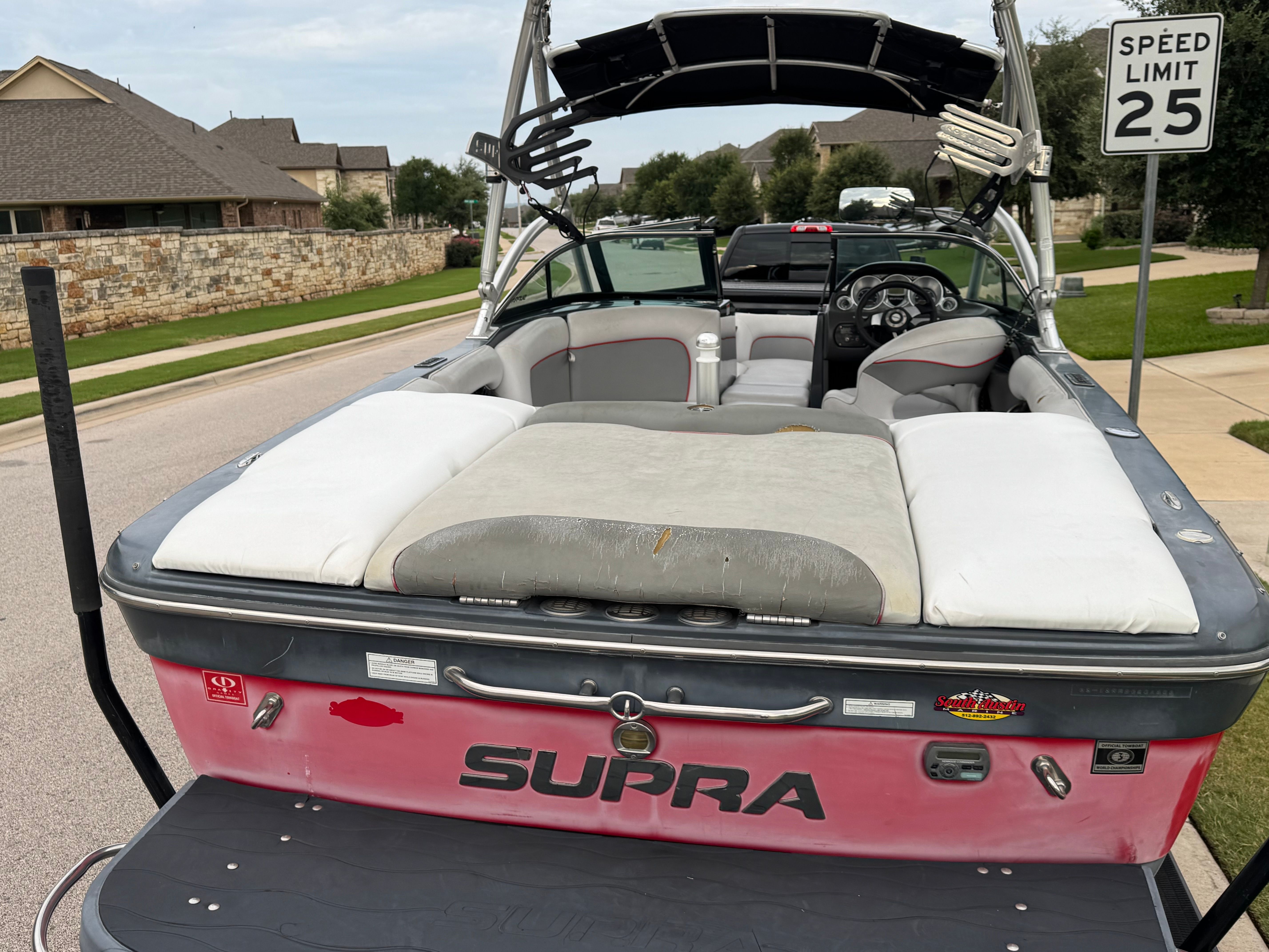 2008 Supra Launch 21 V with spacious interior and tower, parked on a street.