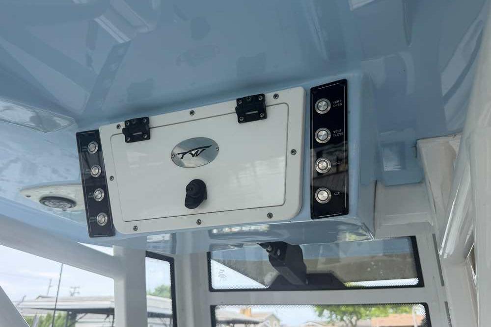 2024 Tidewater 232 LXF boat console with control panel and storage compartment.