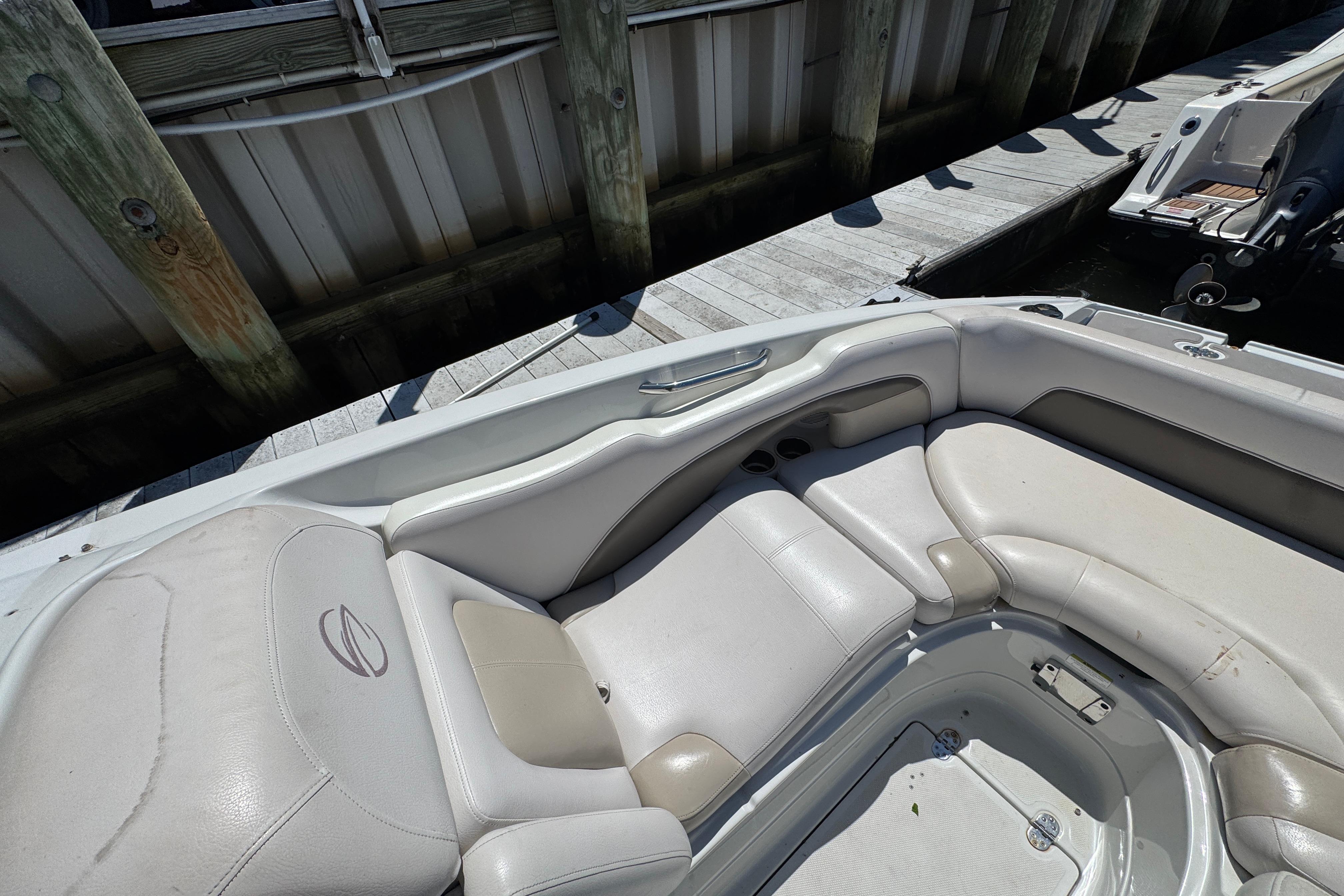 2013 Crownline Eclipse E6 XS boat interior with white and beige seating at dock.