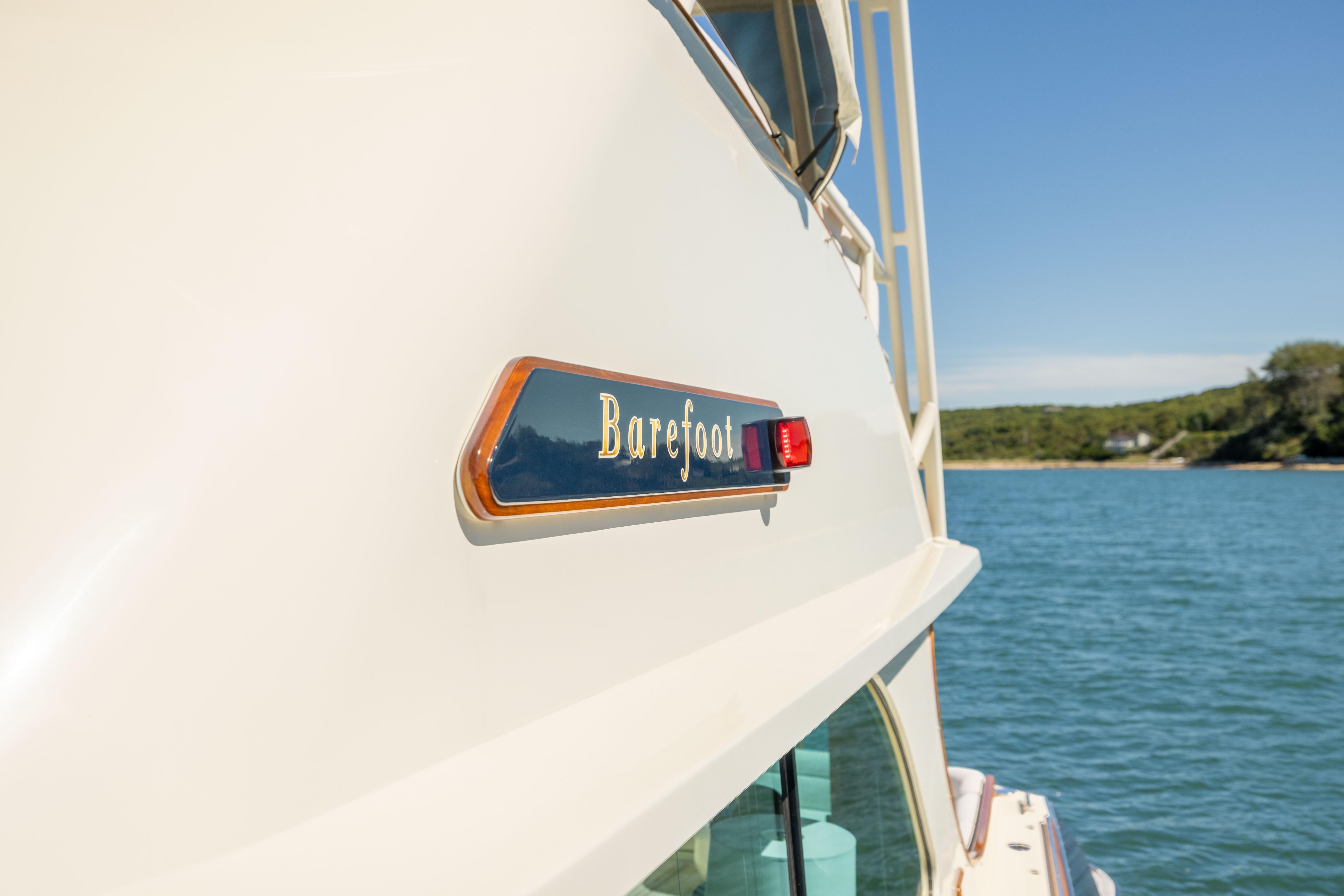 2014 Hinckley Talaria 48 Flybridge yacht on water, featuring "Barefoot" nameplate.