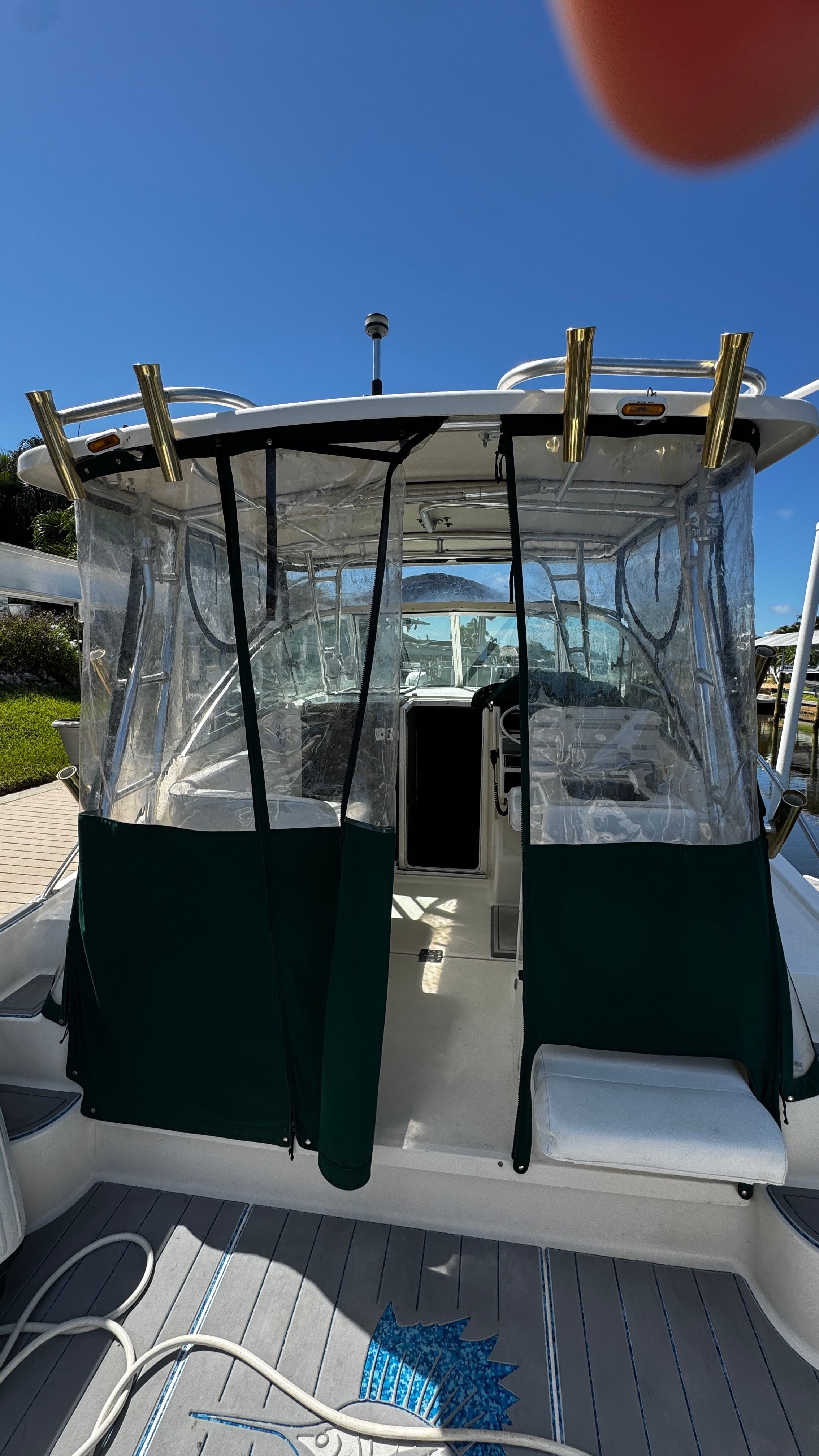 The image shows a 2003 Pursuit 3070 boat with a covered cabin and clear skies.