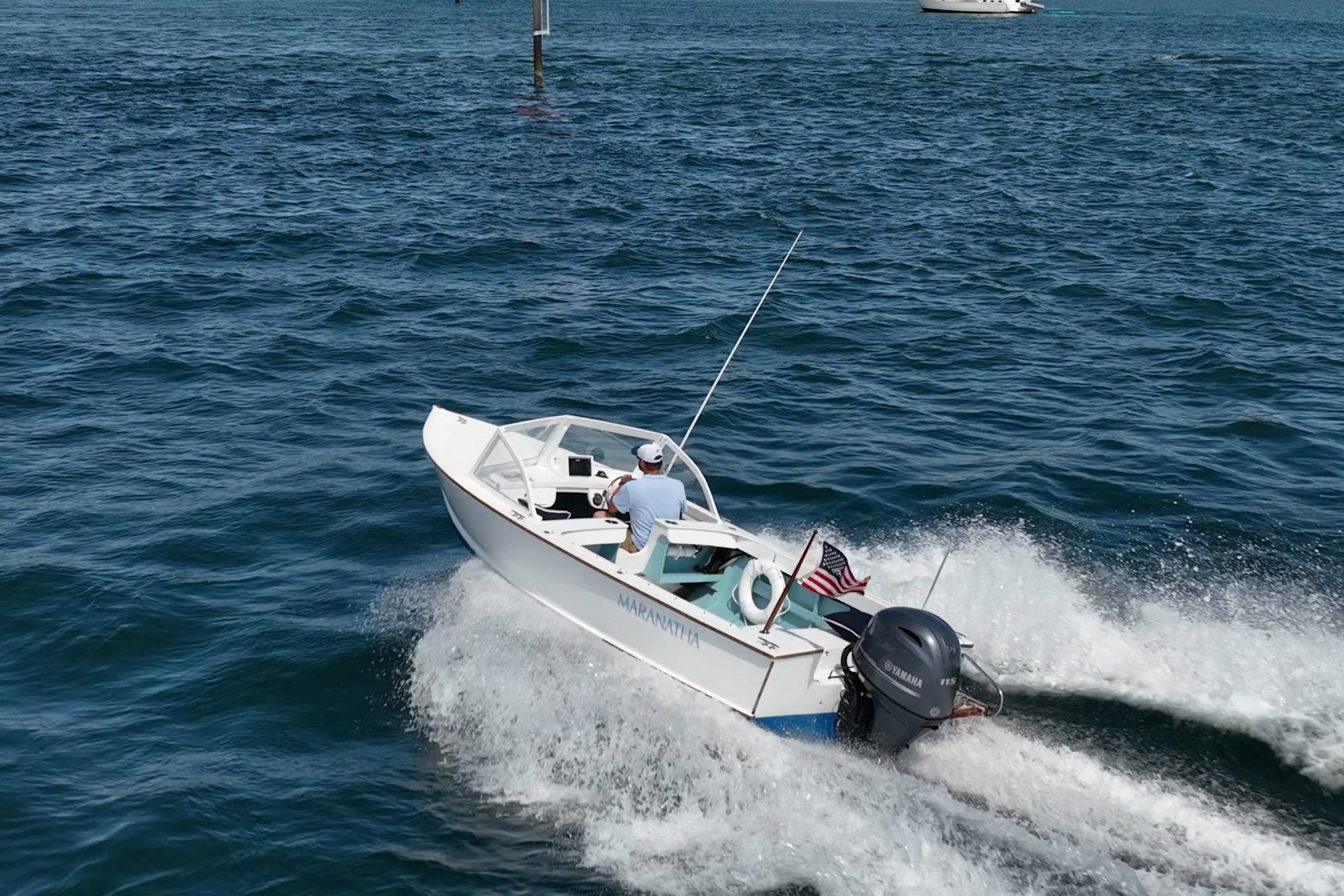 1982 Albury Brothers Runabout cruising on open water with American flag.