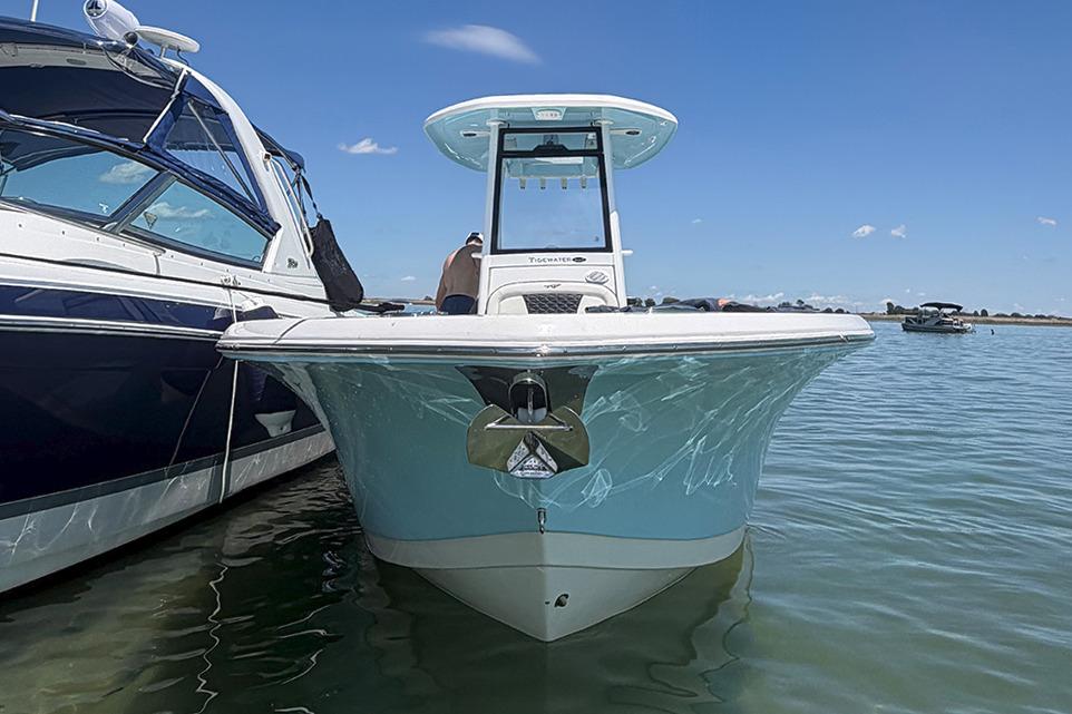 2024 Tidewater 232 LXF boat docked on calm water under clear blue sky.