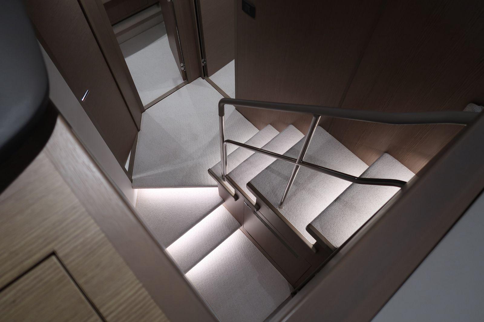 Luxurious interior staircase of 2020 Princess F55 yacht, featuring modern lighting and sleek design.