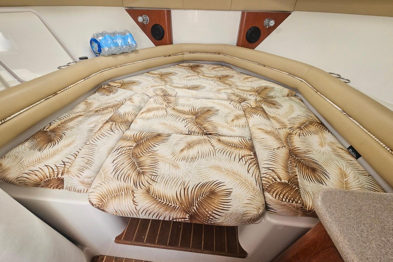 2006 Pro-Line 32 Express cabin interior with patterned bedding and beige seating.