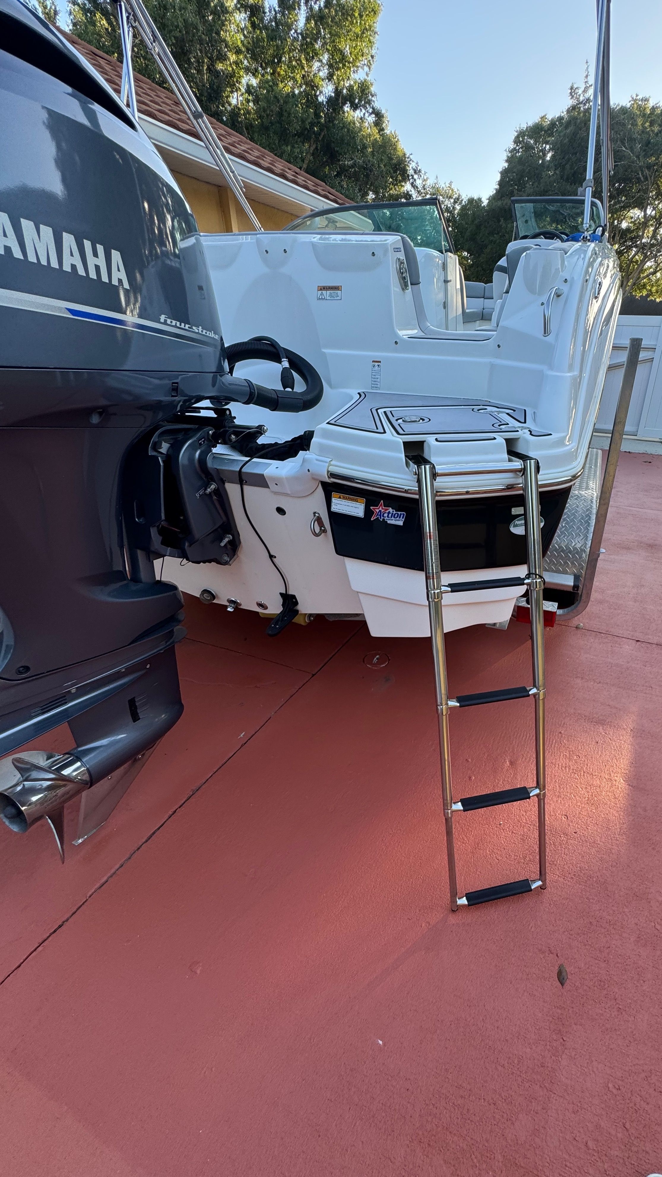 A 2022 NauticStar 243 DC boat with a Yamaha engine. It is on a red surface.