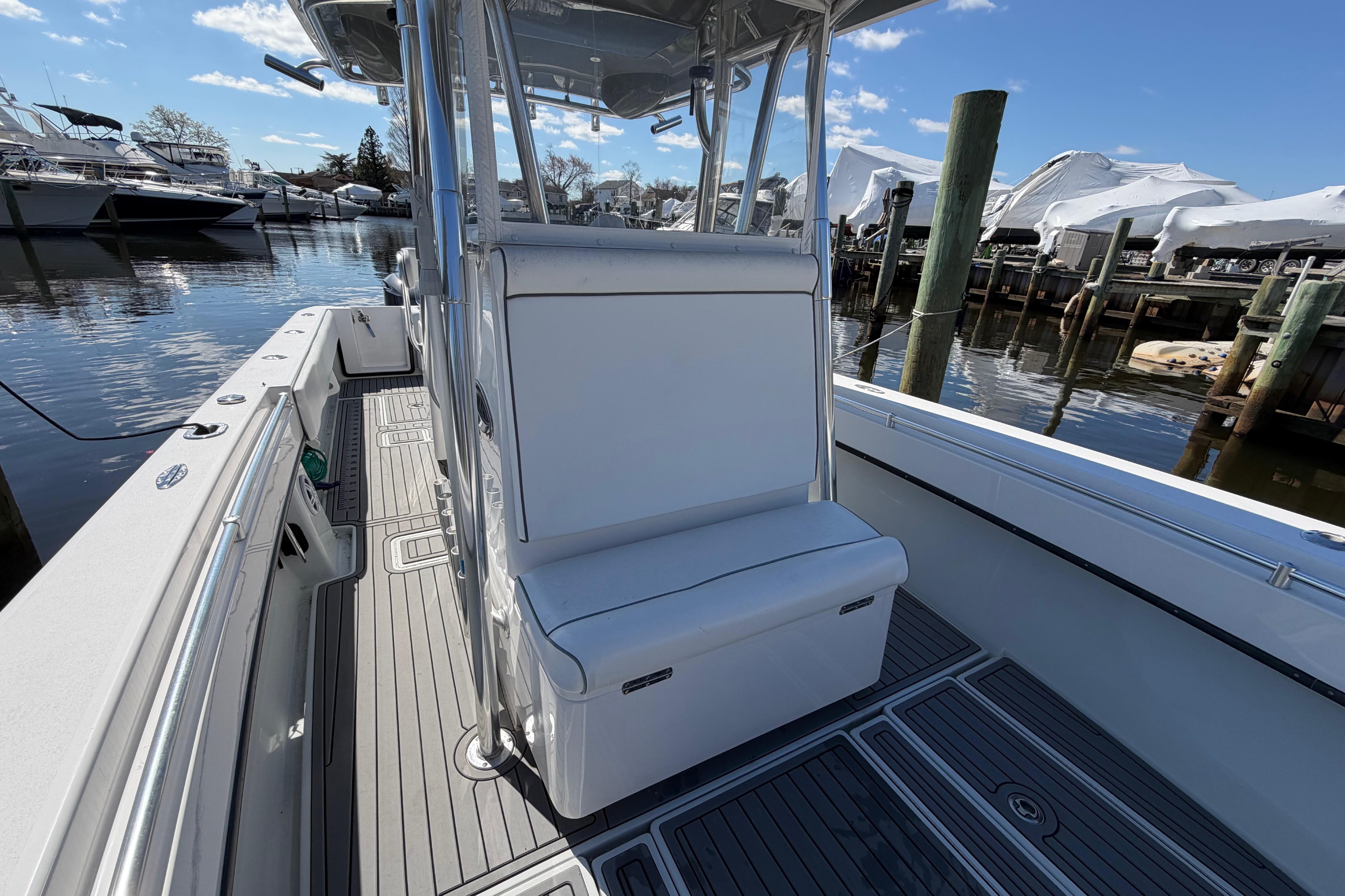 2015 Contender 32 ST boat interior with seating, docked at marina under blue sky.