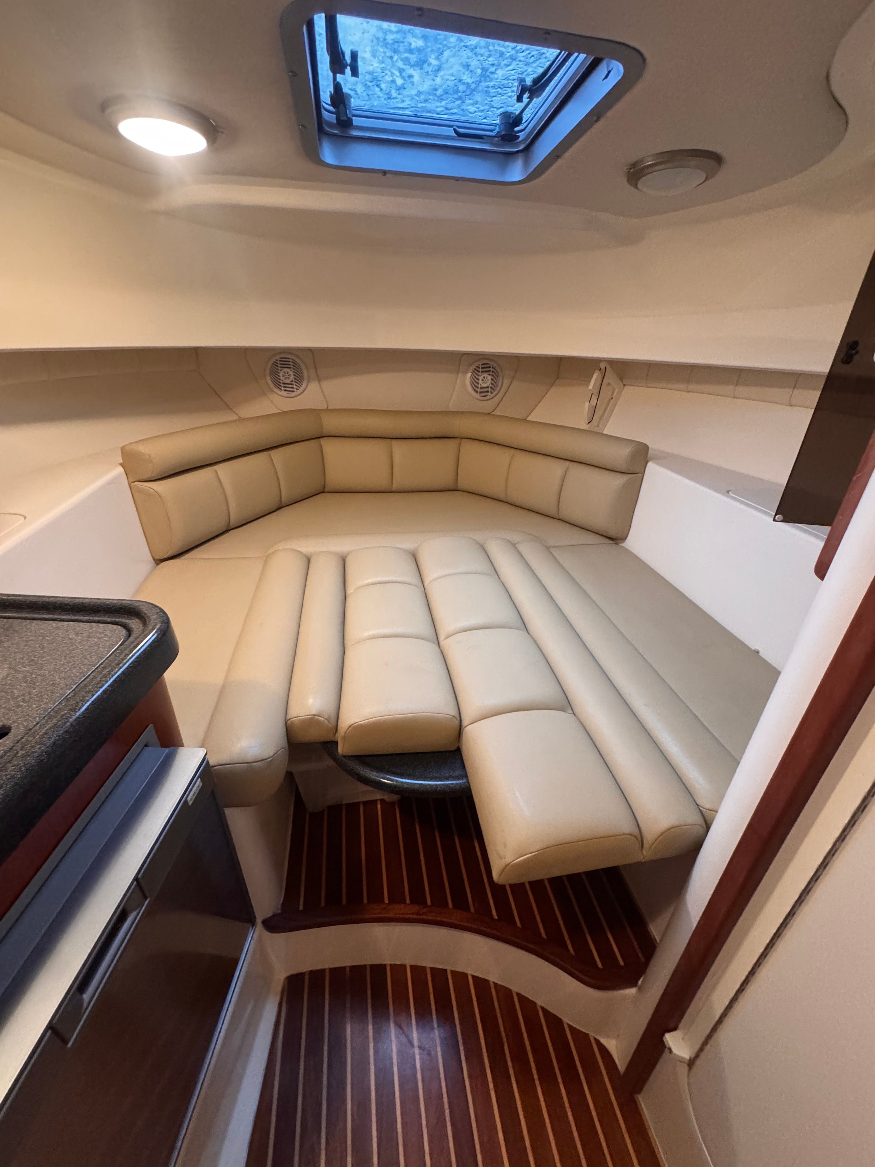 Interior of the 2006 Boston Whaler 305 Conquest with beige upholstered seating and skylights.