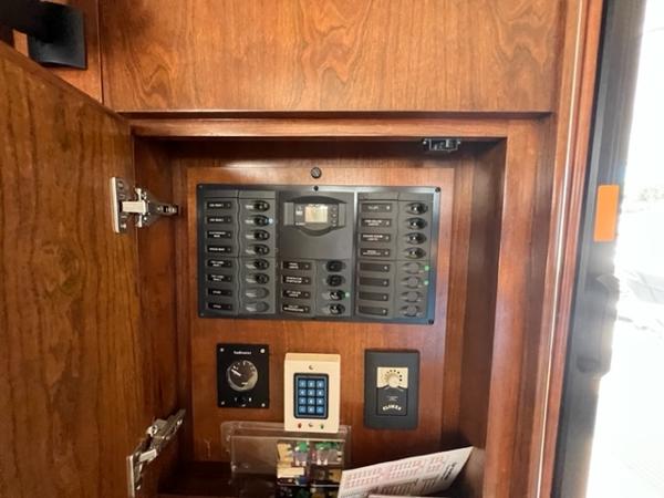 Control panel inside a 2009 Ovation 52 yacht with wooden cabinetry.