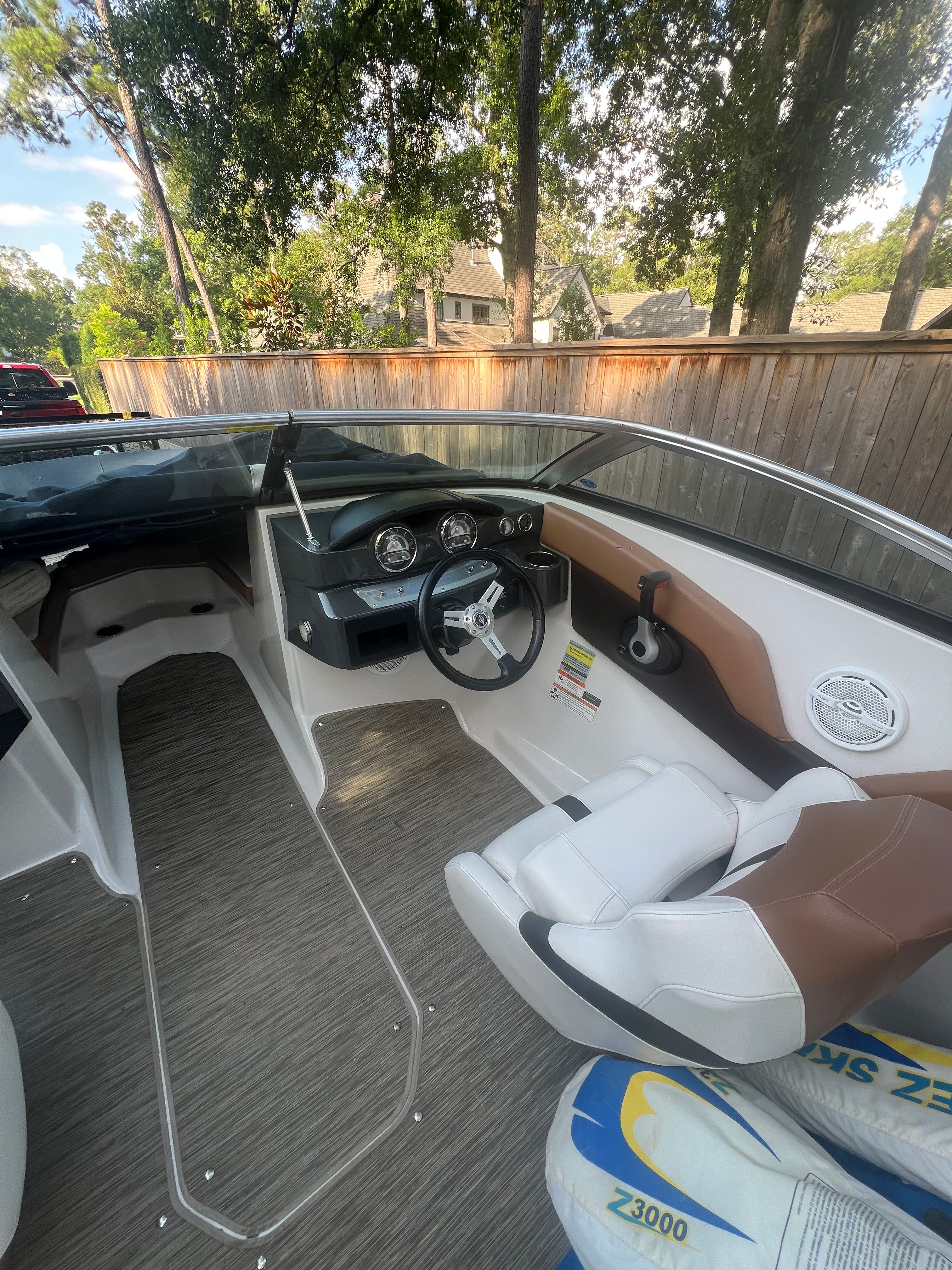 Interior of a 2017 Four Winns H230 boat with steering wheel and seats.