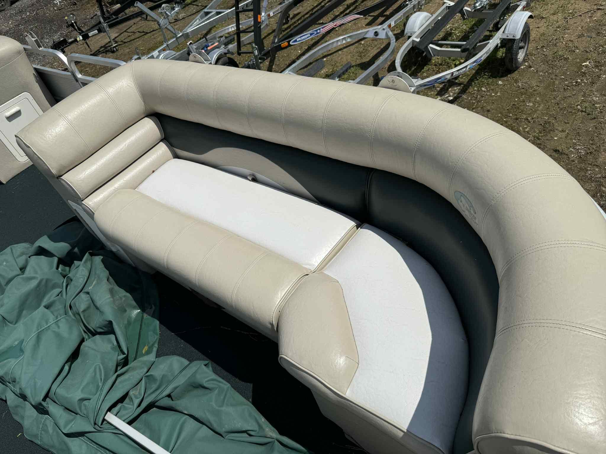 1999 Smoker Craft 8526 Pleasure Isle I/O boat seating with beige upholstery and green cover.