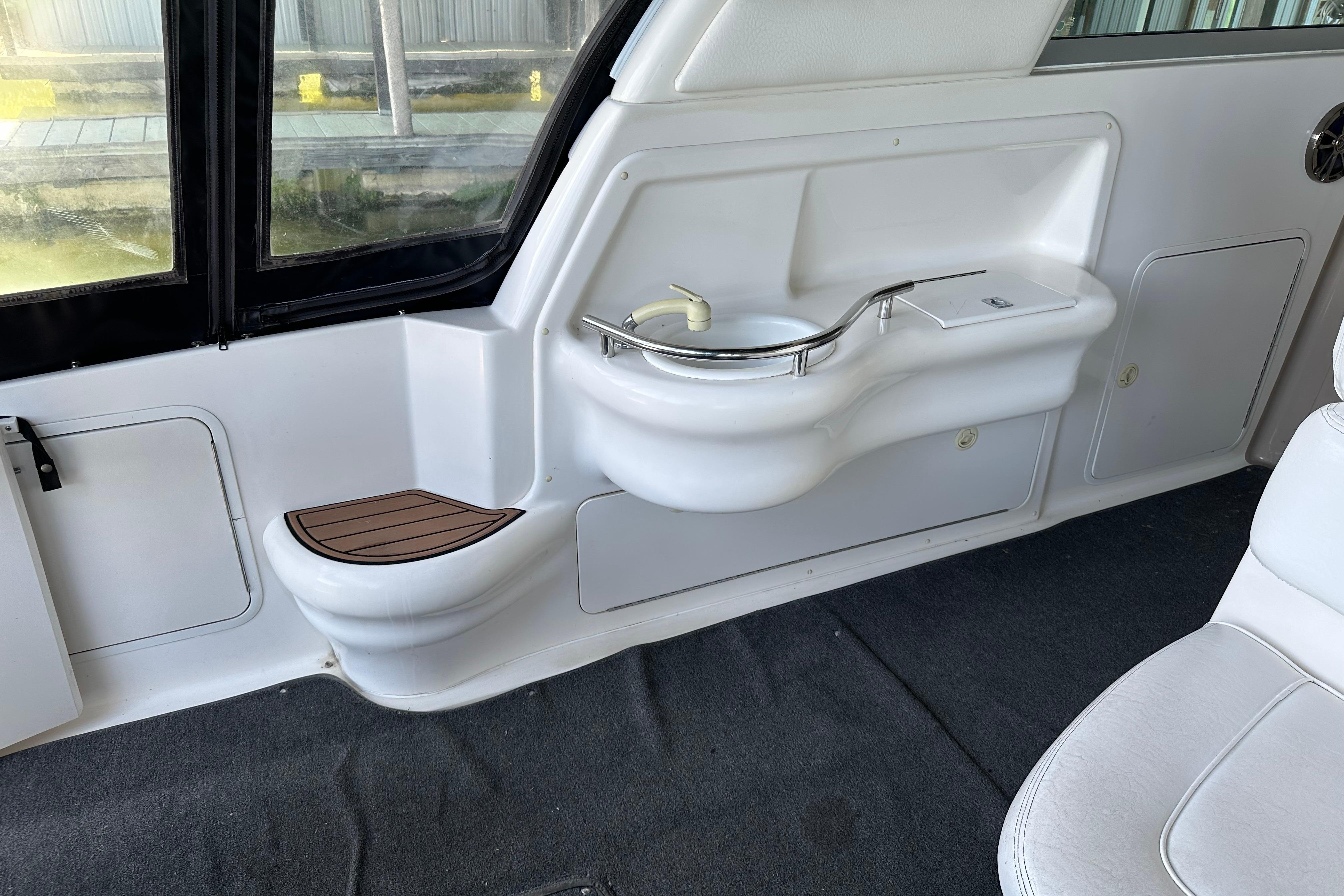 Interior of a 2000 Sea Ray Sundancer 310 boat featuring a compact sink and seating area.