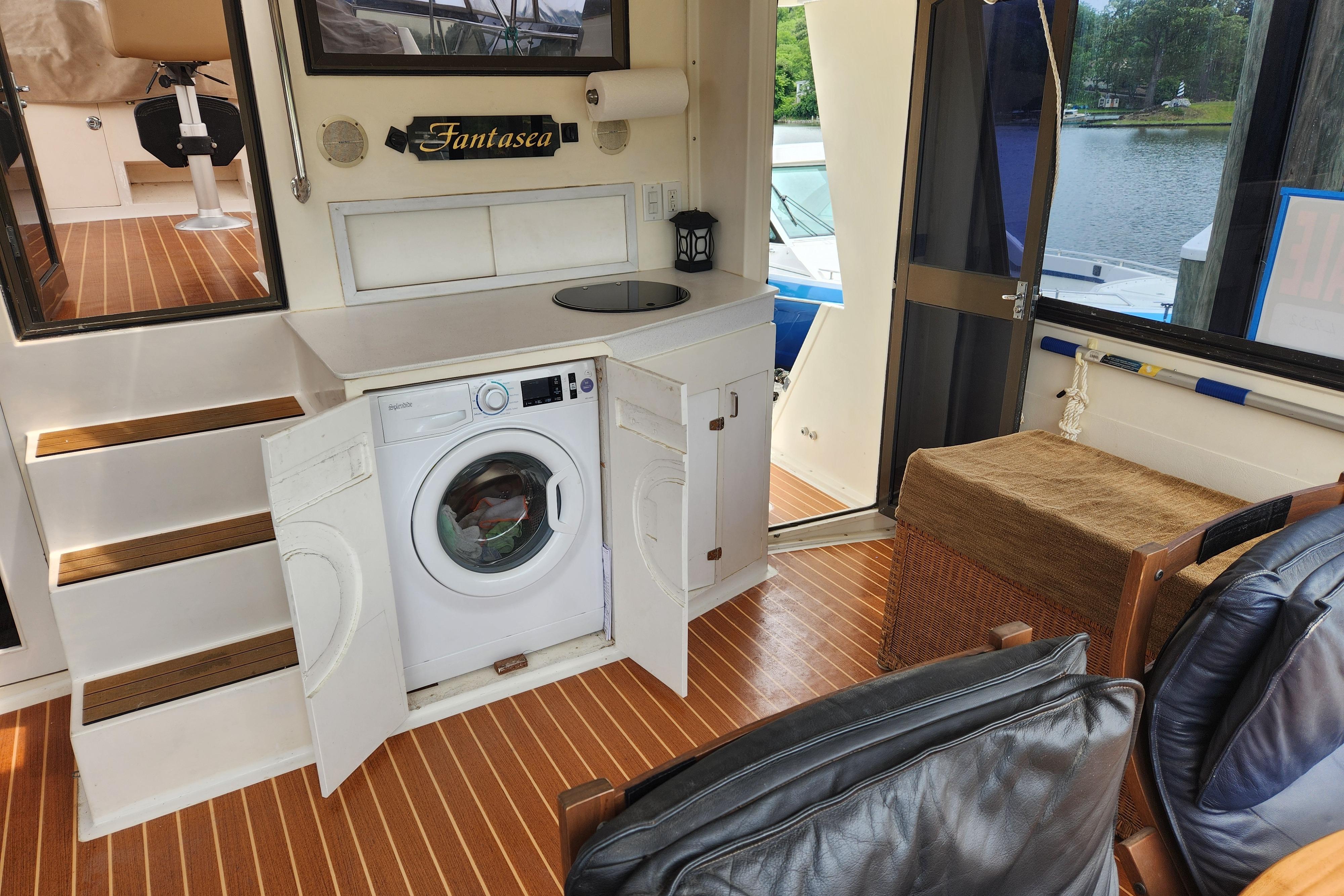 Interior of 1989 Hyatt Double Cabin Motoryacht with washing machine and wooden flooring.