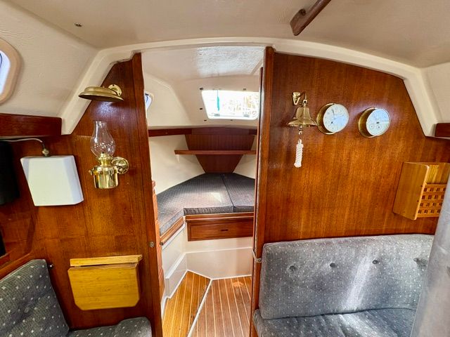 Interior of a 1989 Catalina 34 with wood paneling and cozy seating.