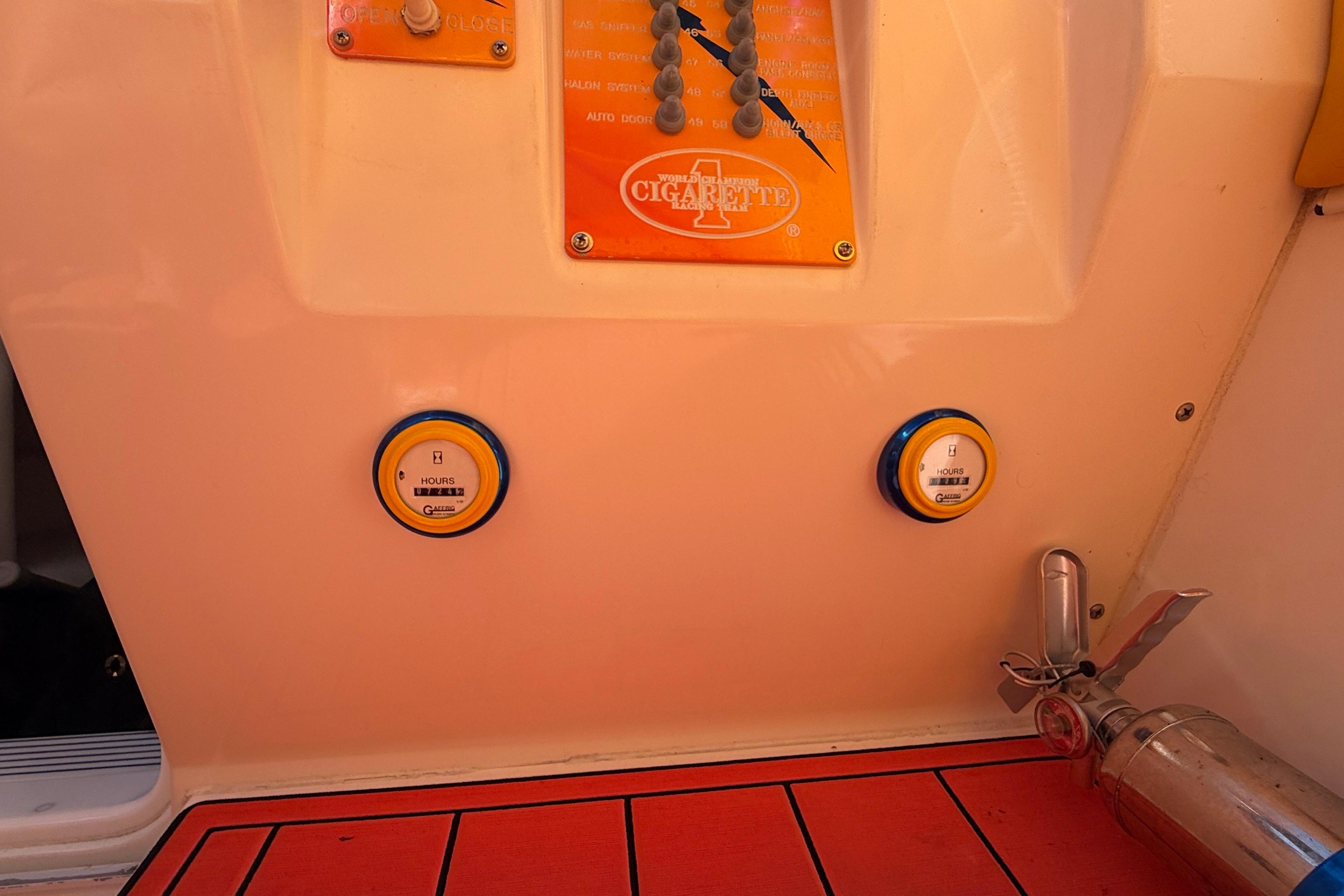 Control panel of a 2002 Cigarette 35' Cafe Racer boat with gauges and fire extinguisher.