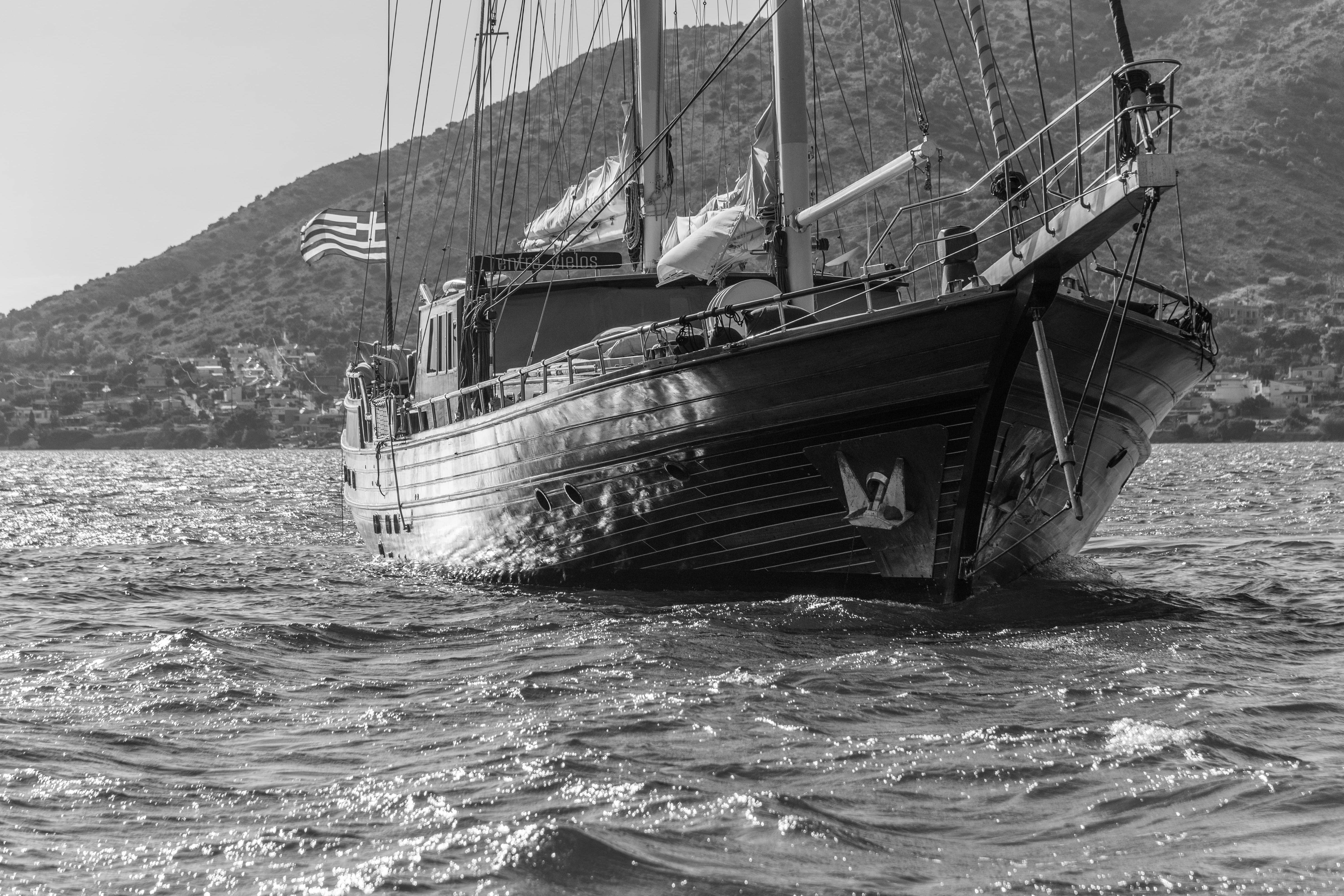 Black and white photo of a 2004 Su Marine Gulet sailing near a mountainous coastline.
