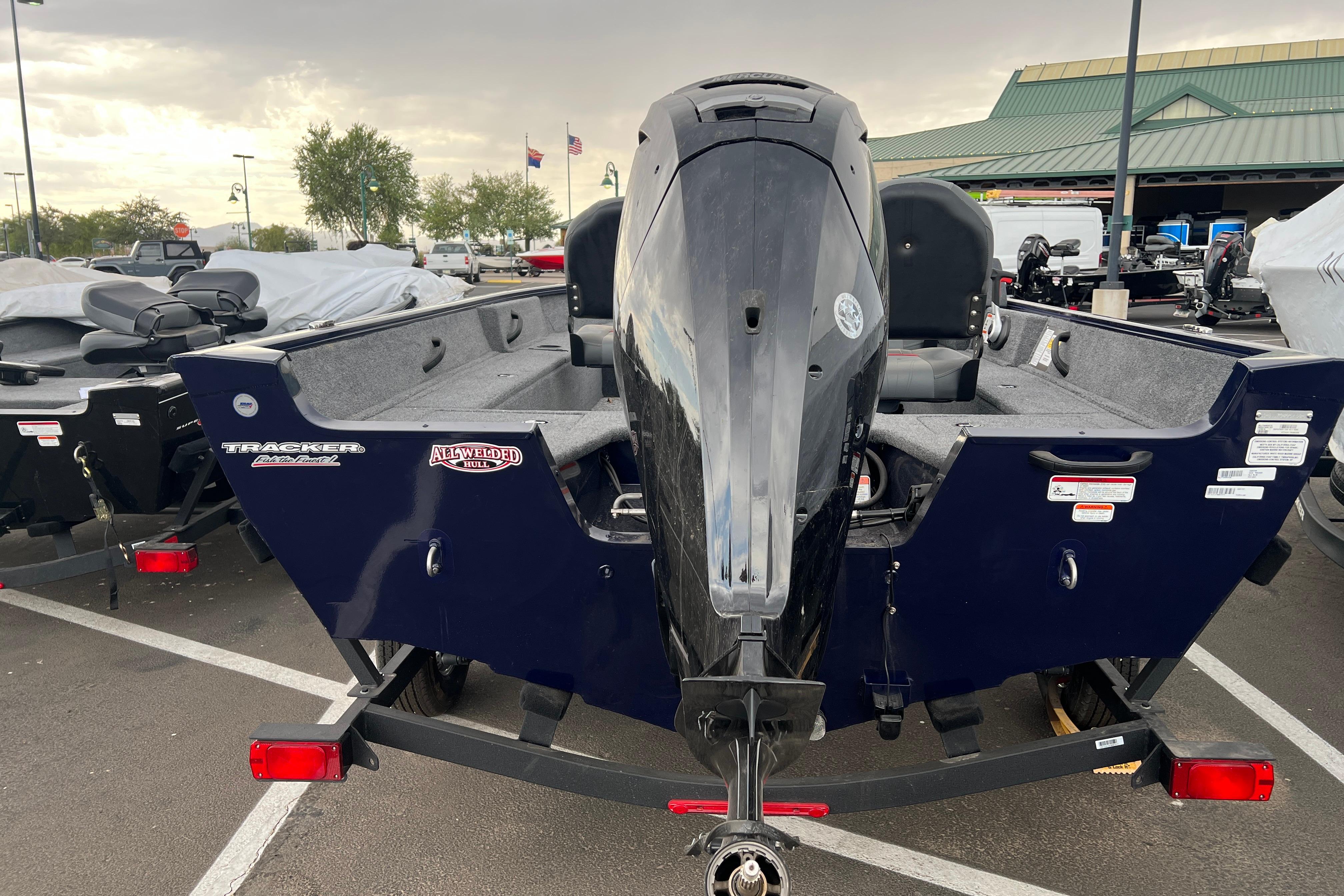 2026 Tracker Pro Guide V-16 SC boat with outboard motor in a parking lot.