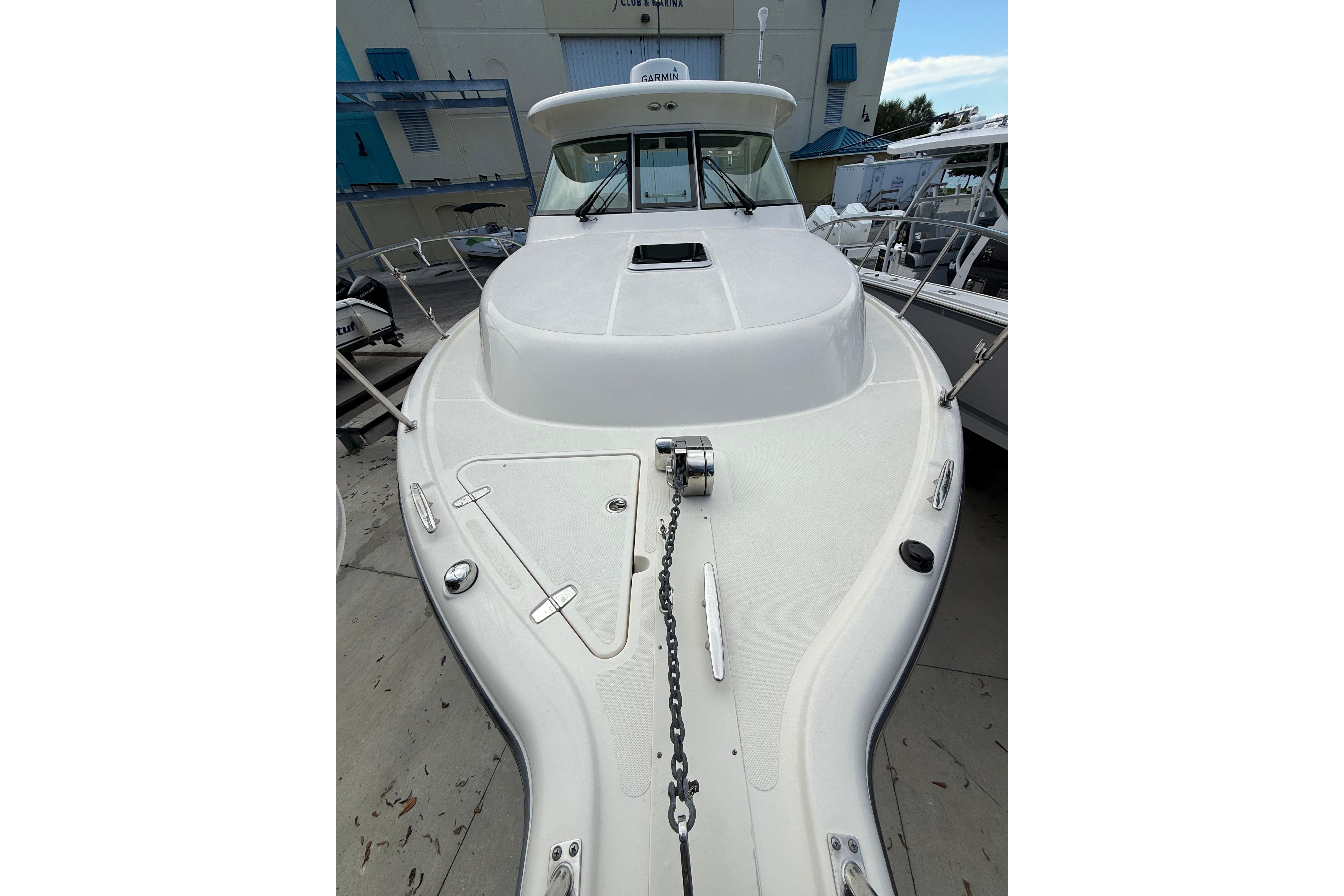 2014 Pursuit OS 345 Offshore boat, white deck view, docked at marina.