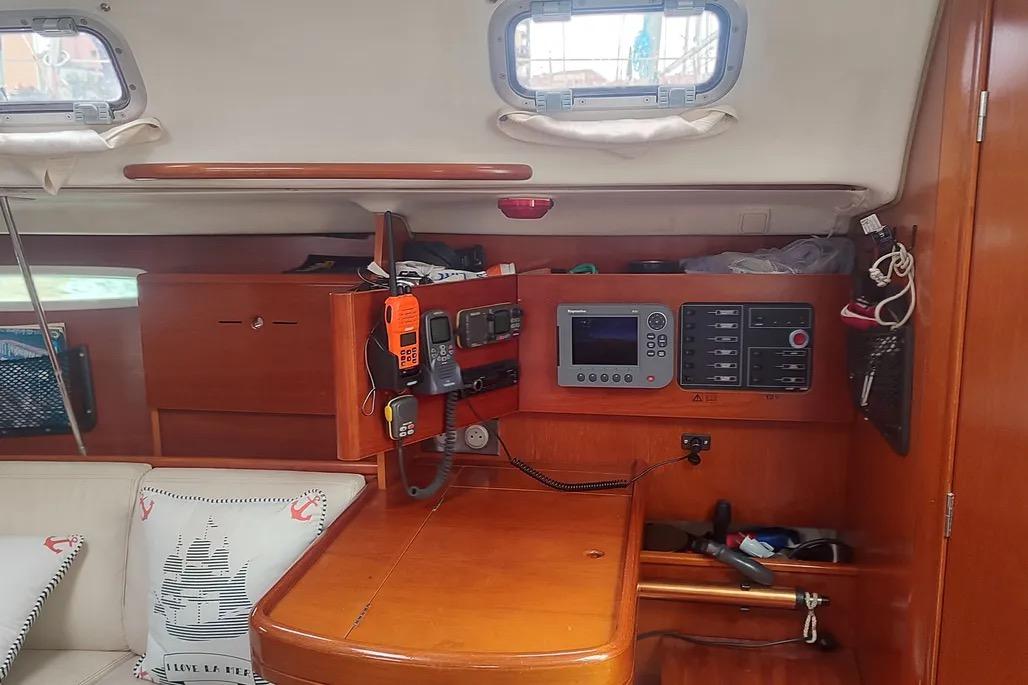 Interior of 2000 Beneteau First 31.7 sailboat with navigation equipment and wooden cabinetry.