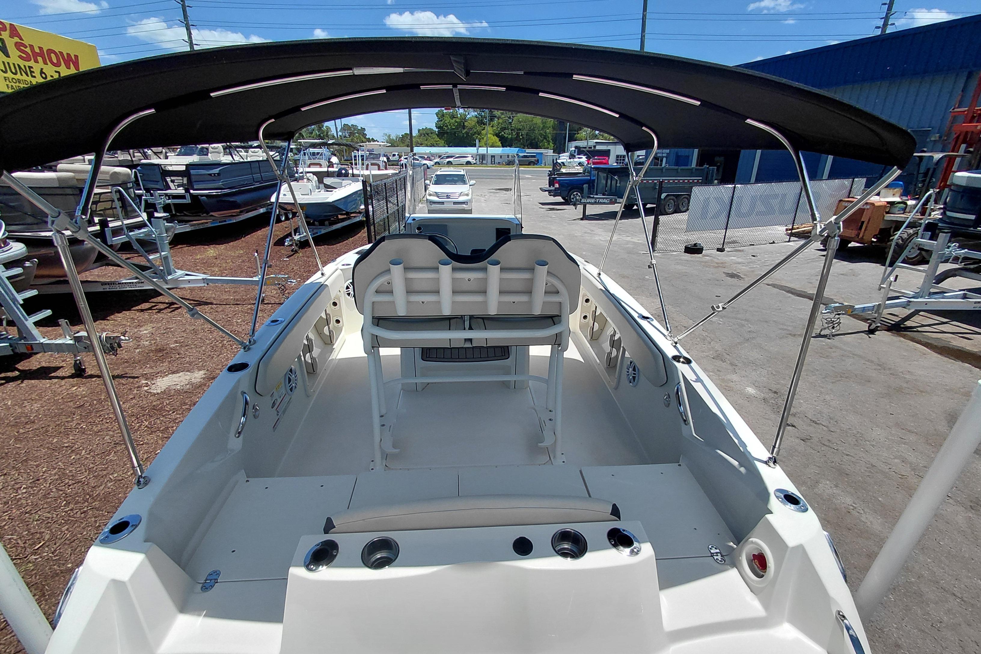 2023 Stingray 206 CC boat with canopy, parked outdoors under clear sky.