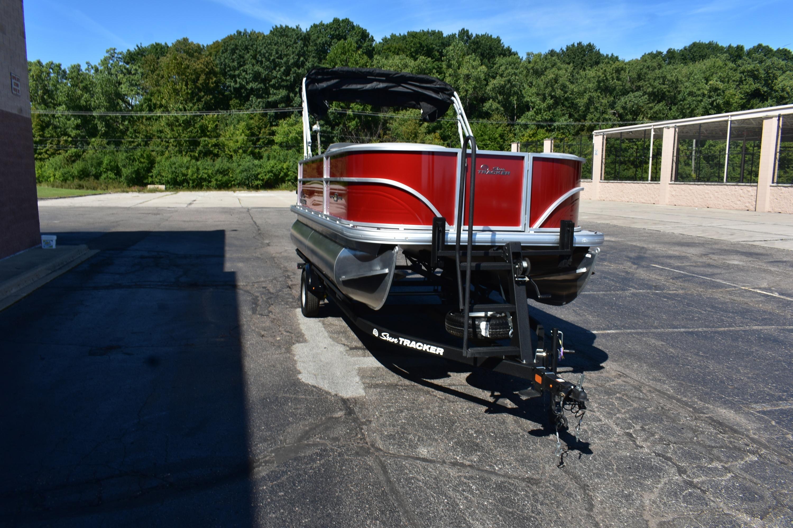 2026 Sun Tracker Party Barge 18 DLX pontoon boat on trailer, parked outdoors.