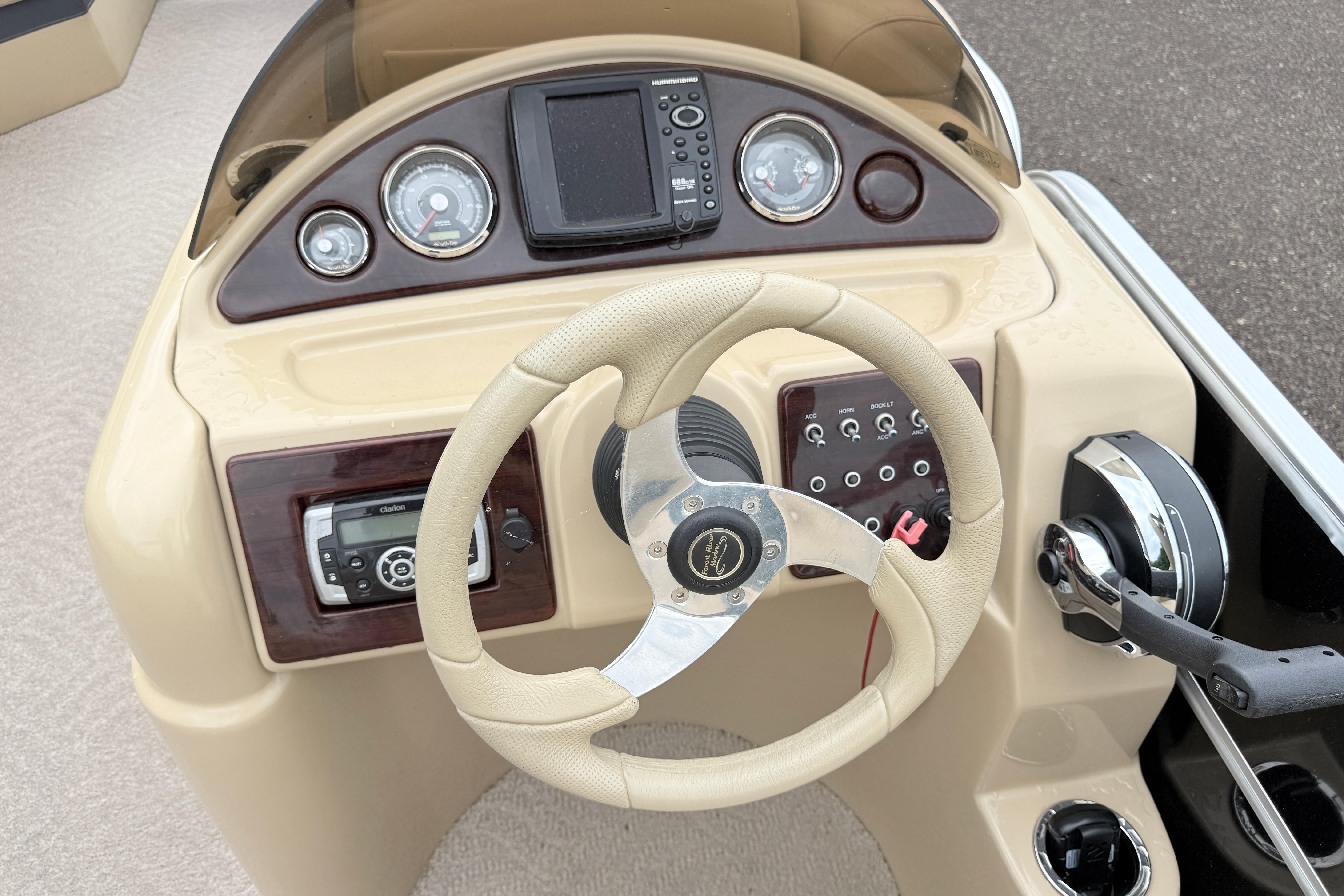 Steering console of a 2013 South Bay 522CR boat with gauges and controls.