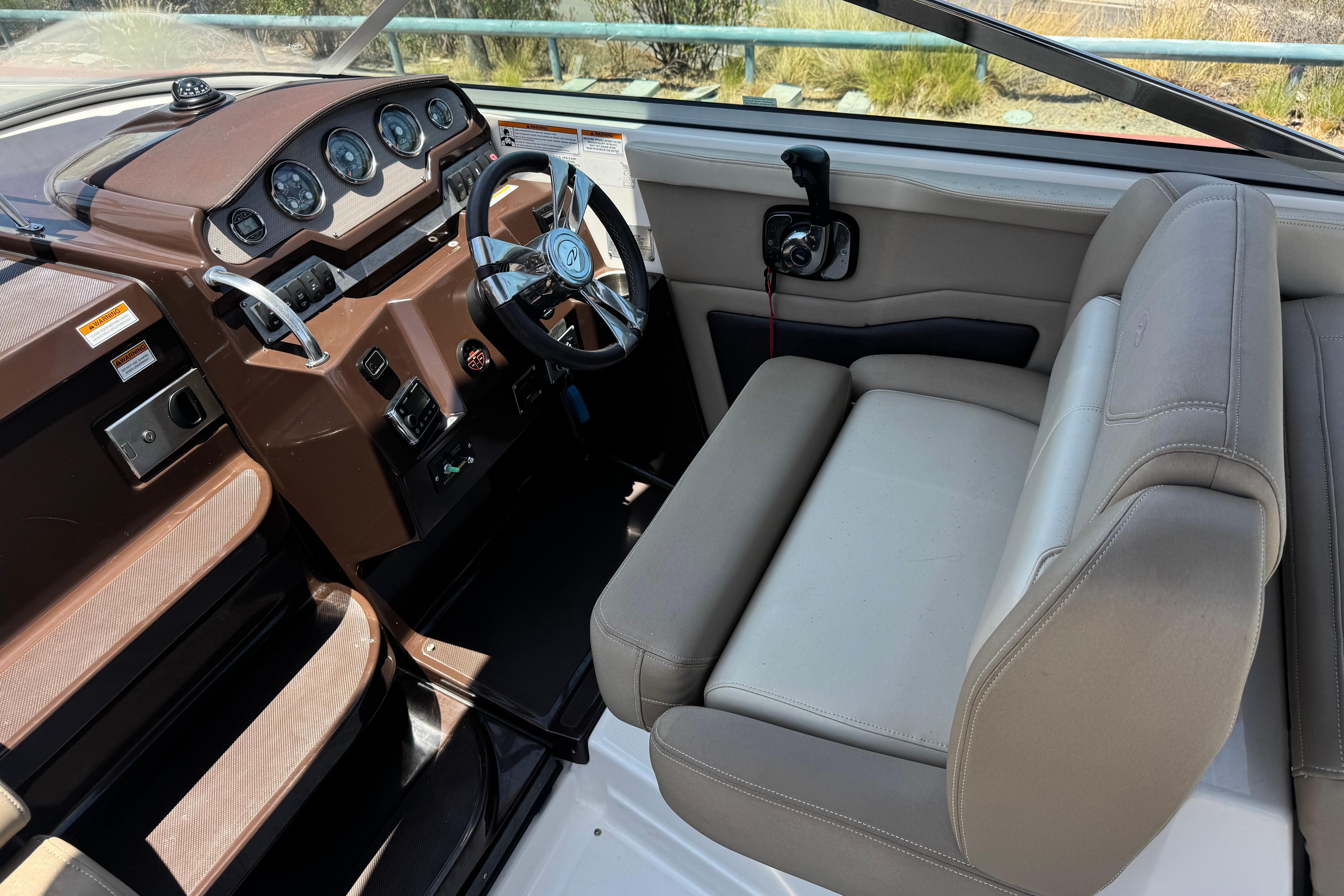 Interior of a 2013 Regal 28 Express boat showing steering wheel and dashboard controls.