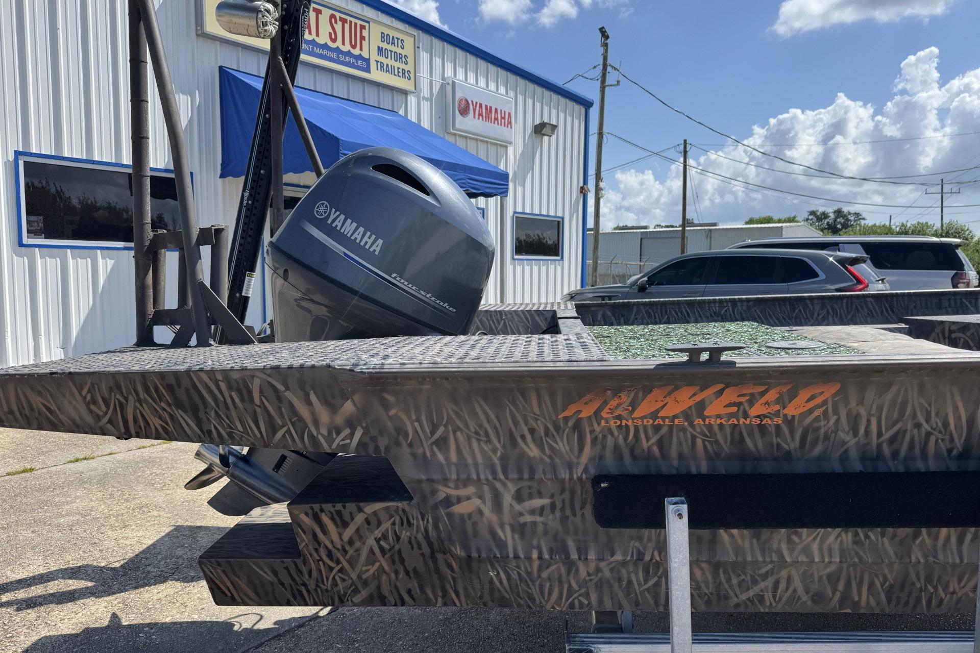 2022 Alweld 2270 Large Flat Bottom boat with Yamaha motor, parked outside a marine supply store.