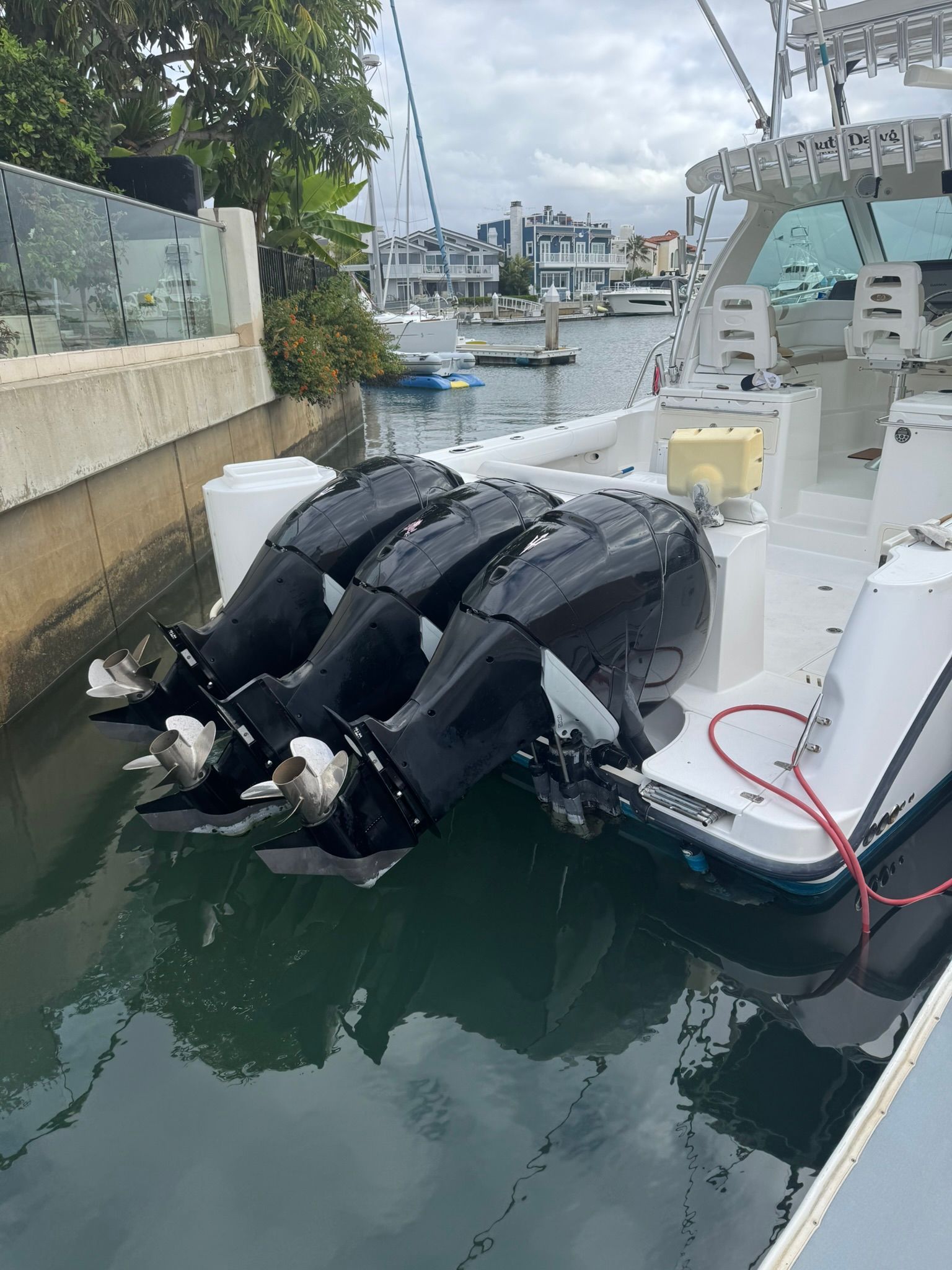Three outboard engines on a Boston Whaler 345 Conquest docked in a marina.