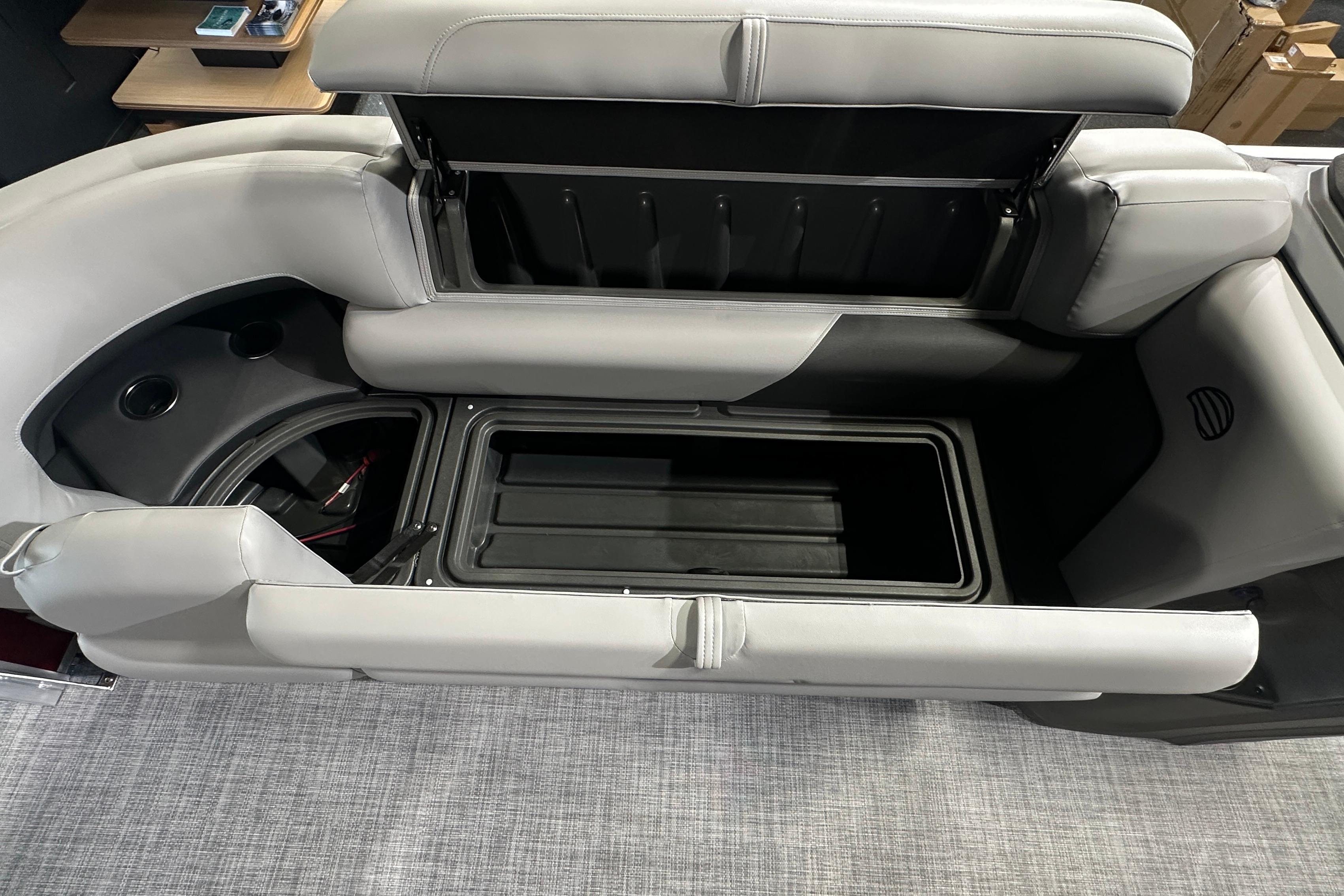 2026 Sun Tracker SportFish 22 DLX boat interior storage compartment with cushioned seating.