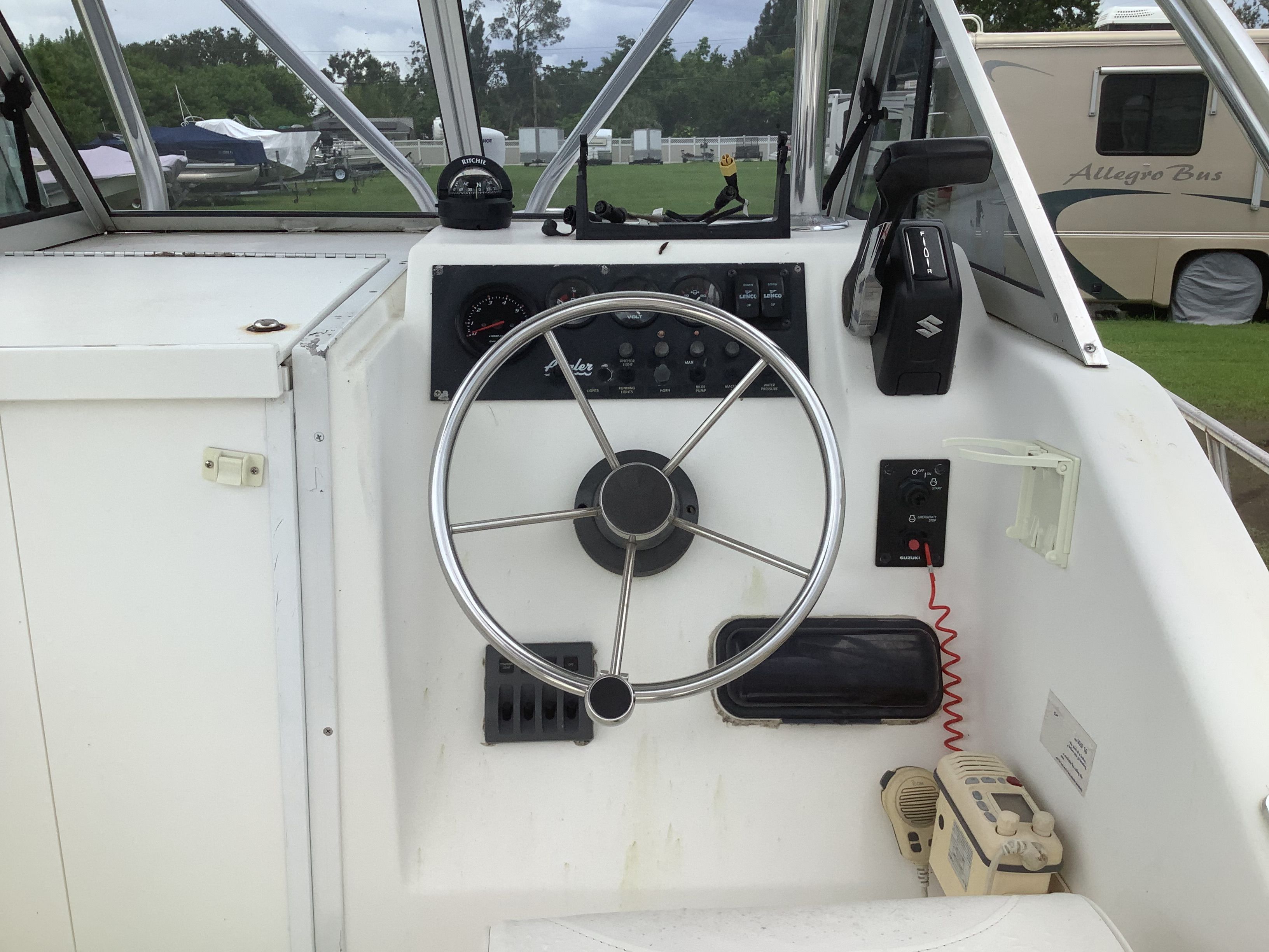 The cockpit of an Angler 204 boat with steering wheel and instrument panel.