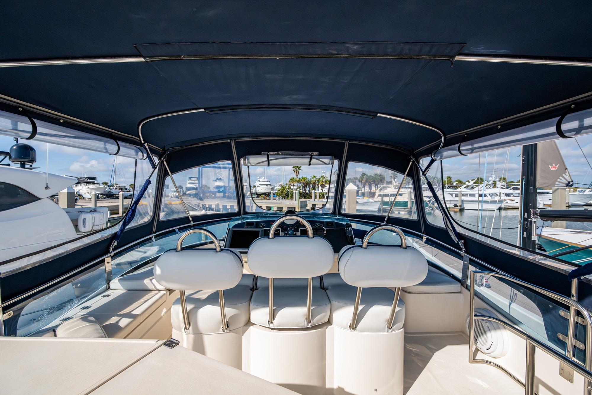 Interior view of 2000 Fairline Squadron 52 yacht at marina, featuring helm and seating.