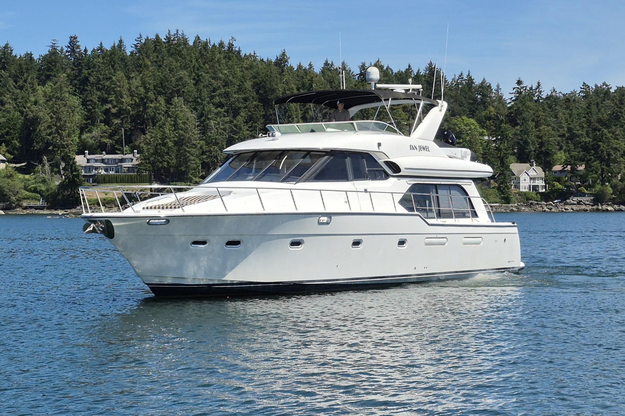 1998 Bayliner 5788 Pilot House Motoryacht cruising on a serene lake.