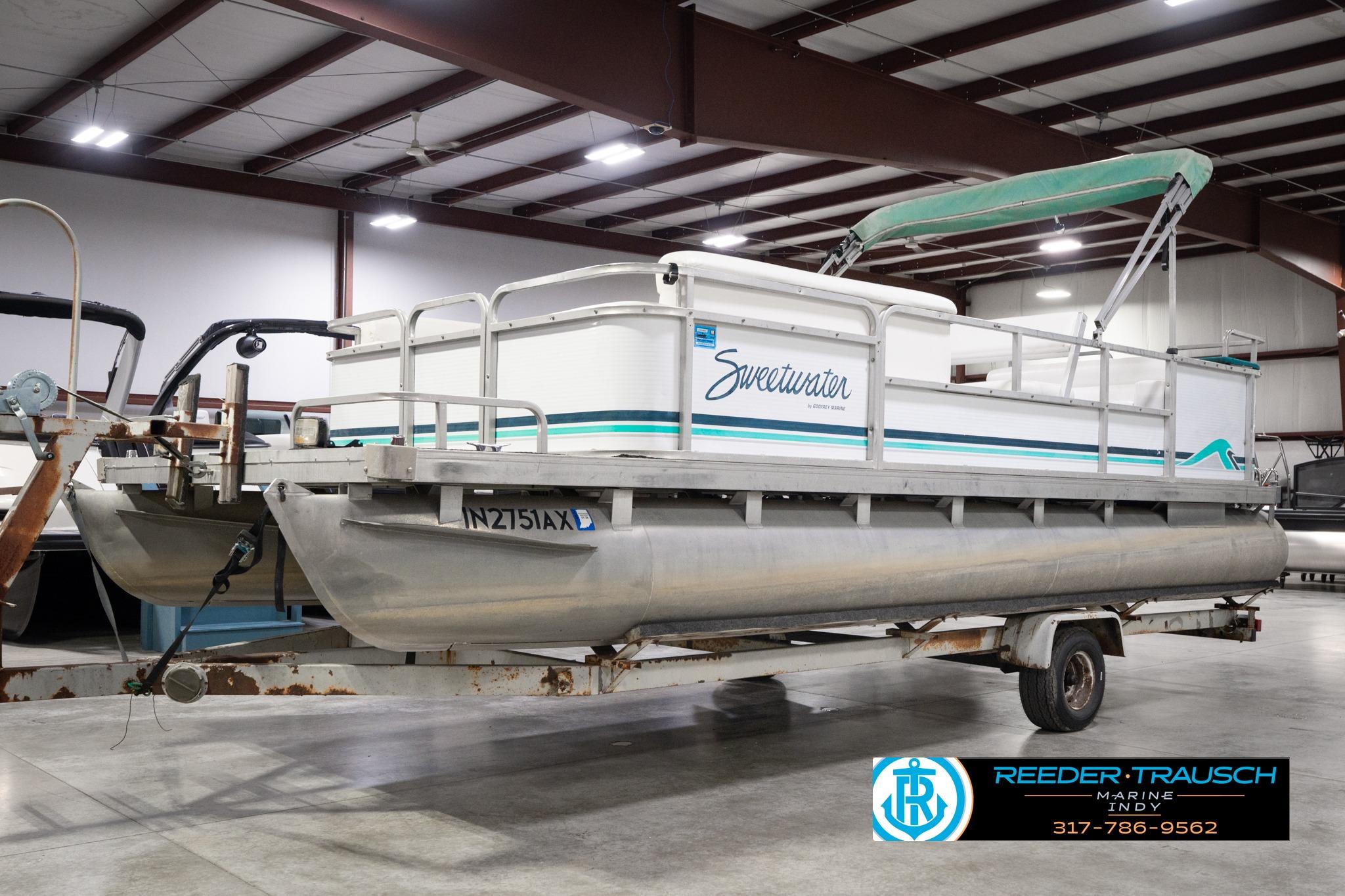1992 Godfrey Sweetwater pontoon boat in indoor storage on a trailer.