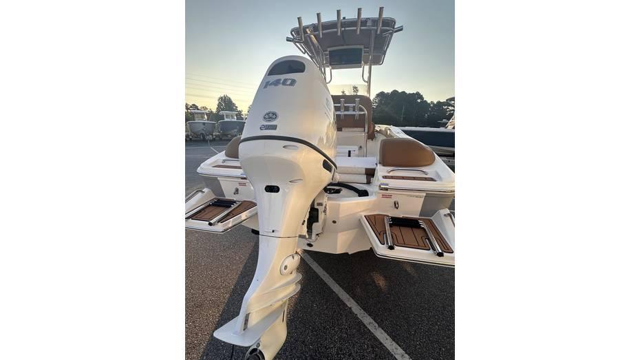 2025 Pioneer 202 Islander boat with powerful outboard motor, docked at sunset.