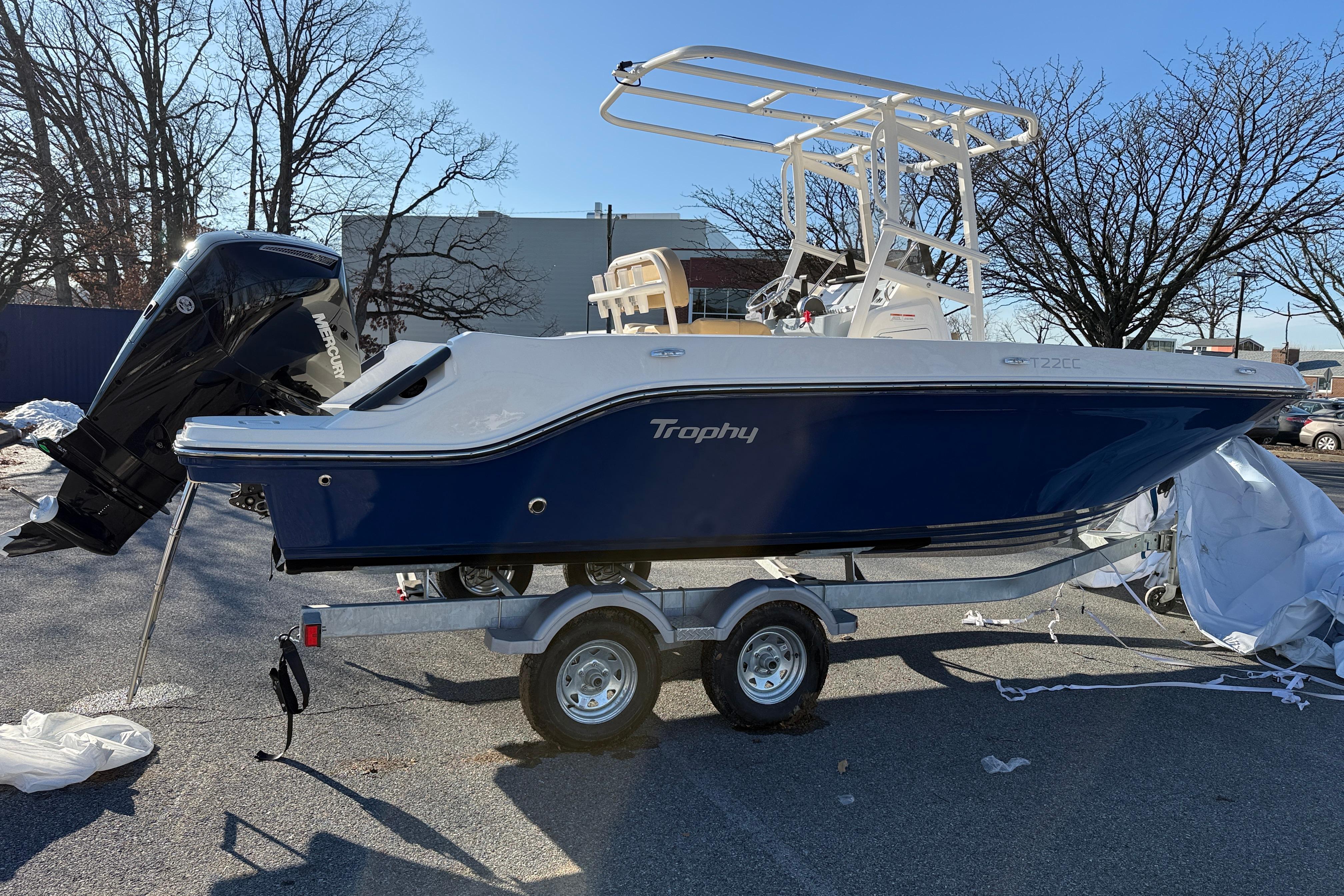 2026 Bayliner Trophy T22CC boat on trailer, parked outdoors.