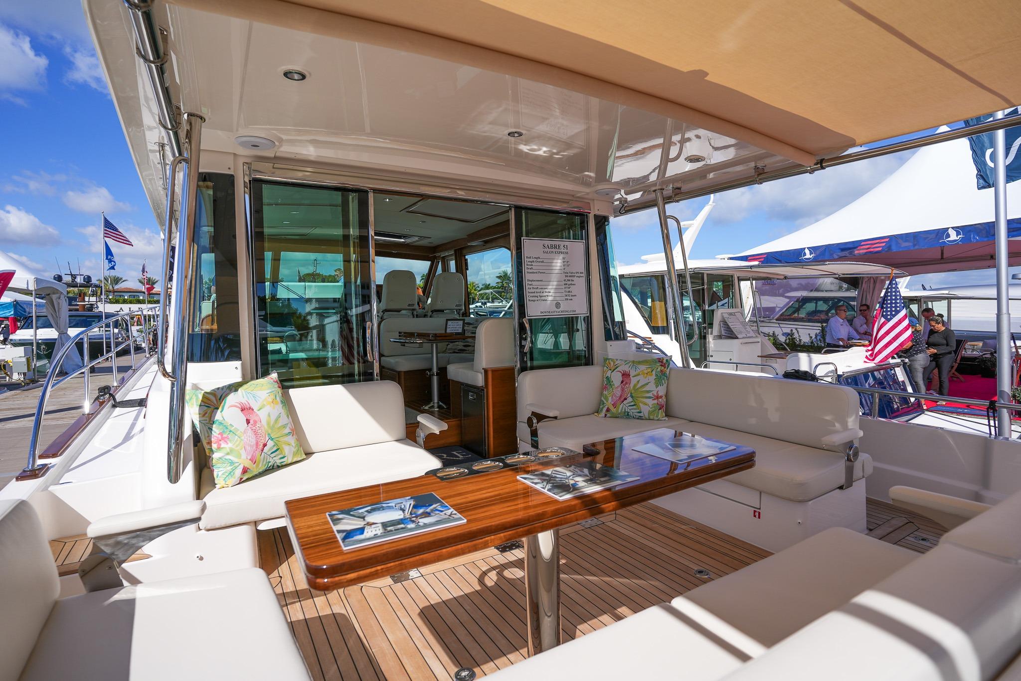 Luxurious 2026 Sabre 51 Salon Express yacht interior with elegant seating and wooden table.