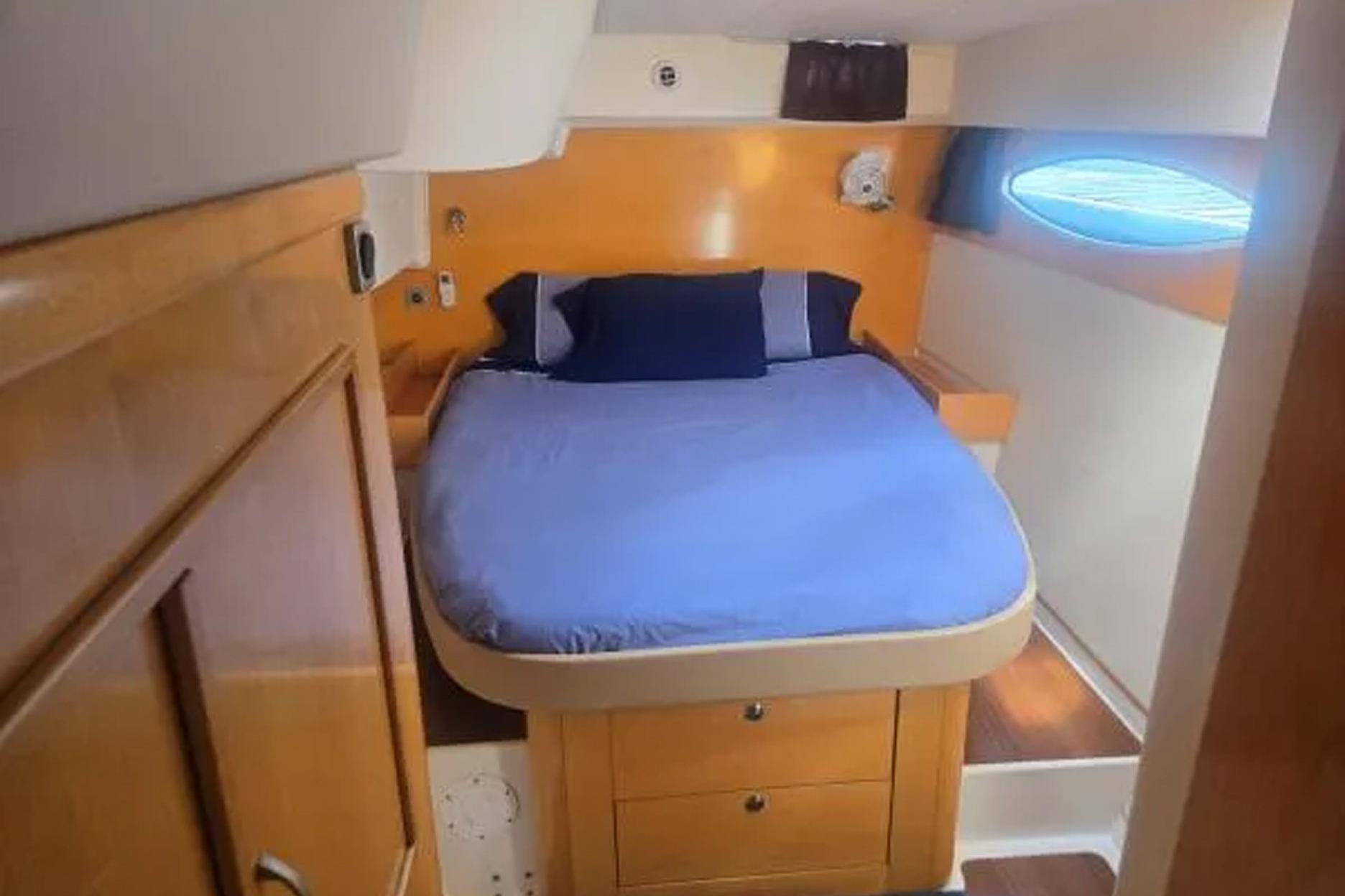 Cozy cabin interior of 2008 Fountaine Pajot Salina 48 catamaran with bed and porthole.