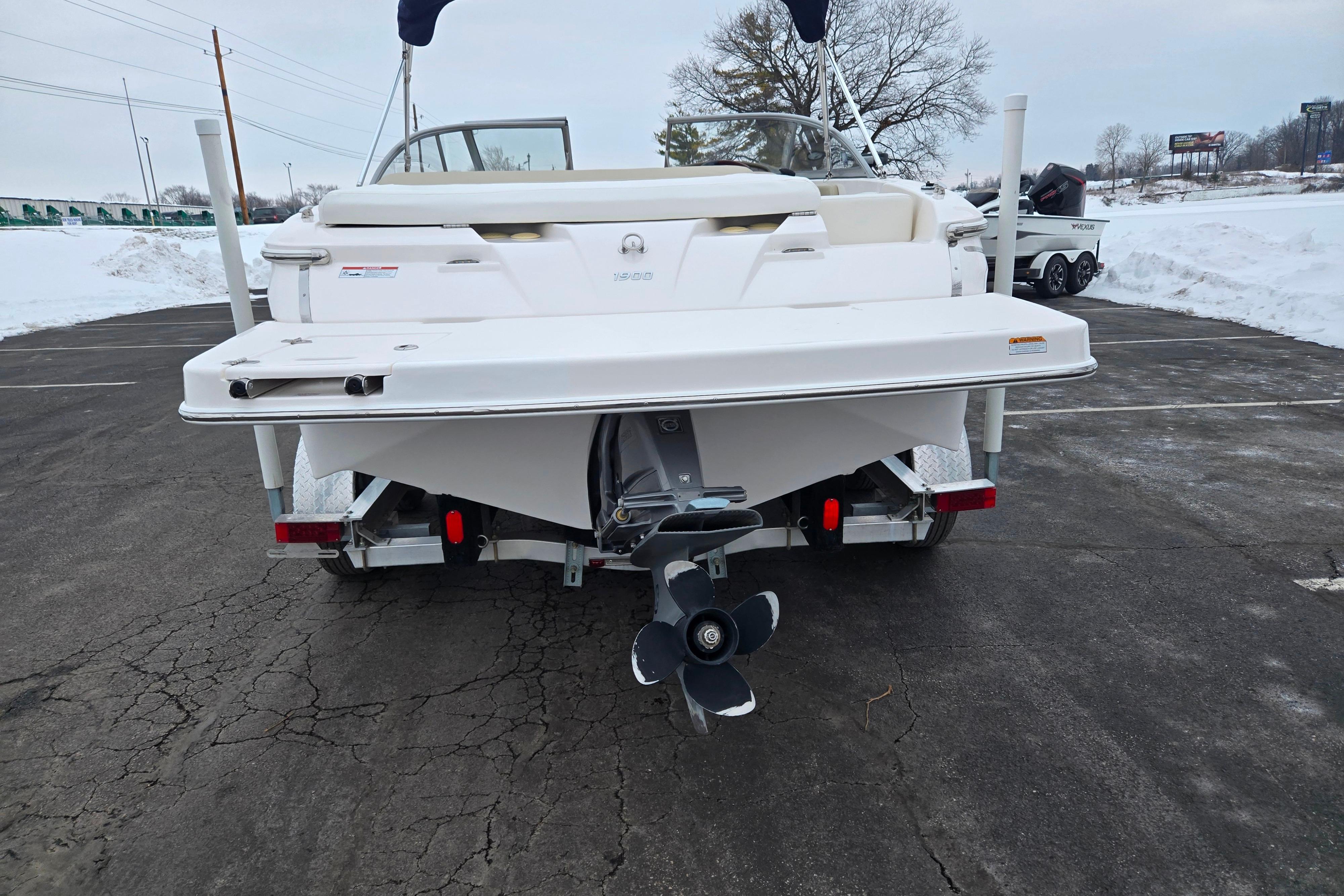 2015 Regal 1900 ES Bowrider boat on trailer, rear view in snowy parking lot.