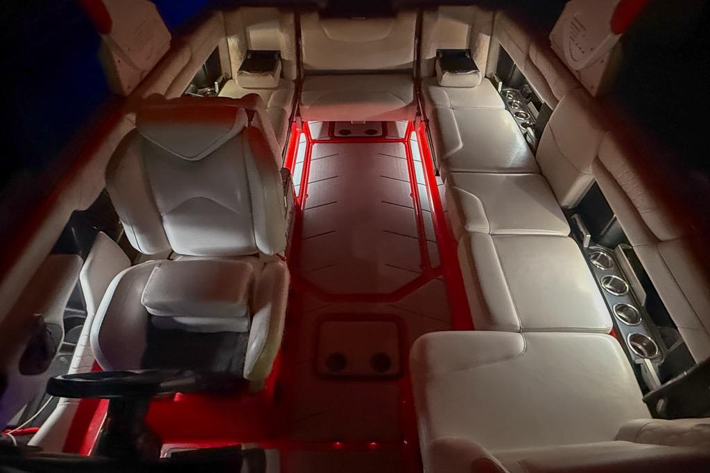 Luxurious interior of 2021 Malibu M240 boat with ambient red lighting.