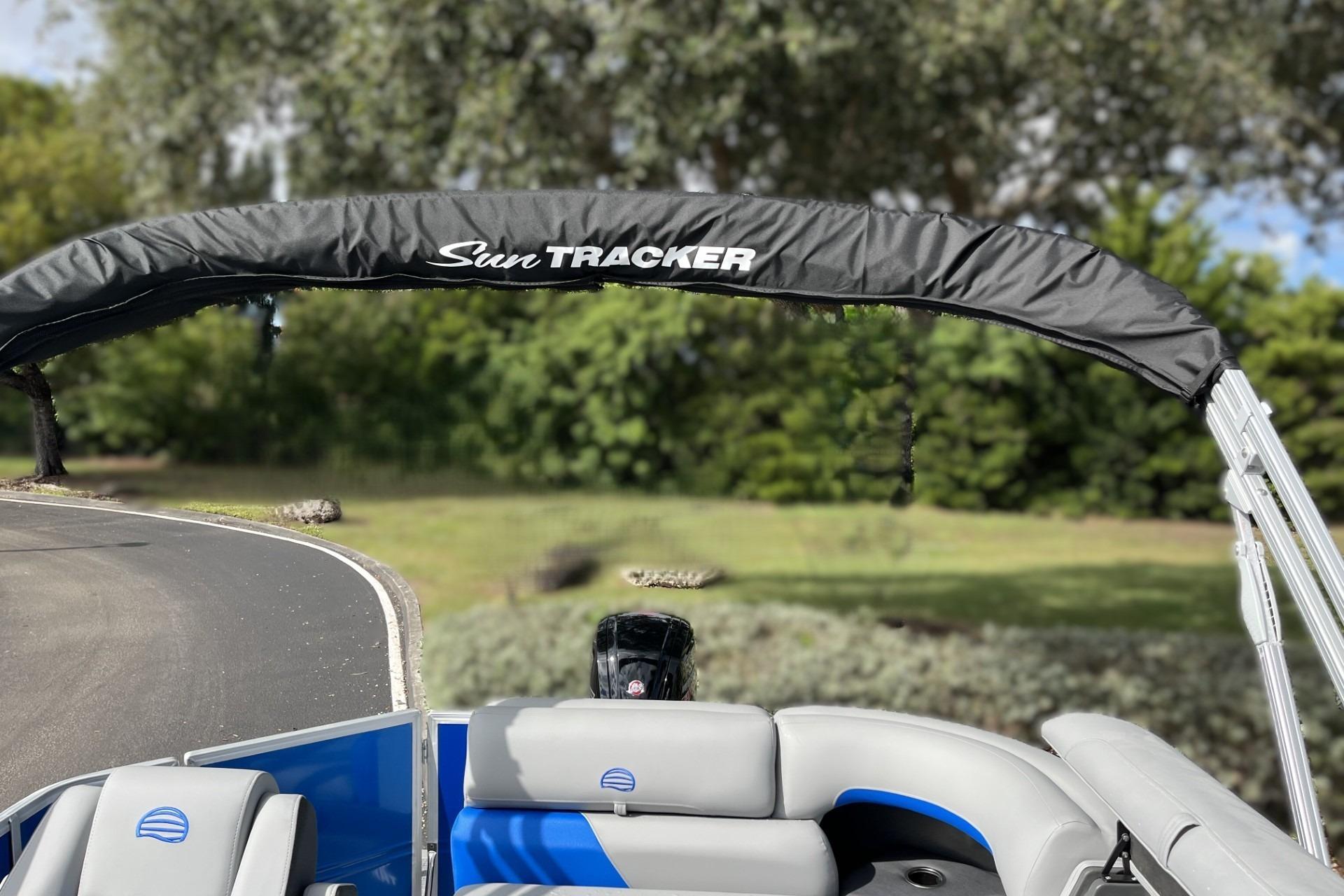 2026 Sun Tracker Party Barge 20 DLX pontoon boat with canopy, parked outdoors.