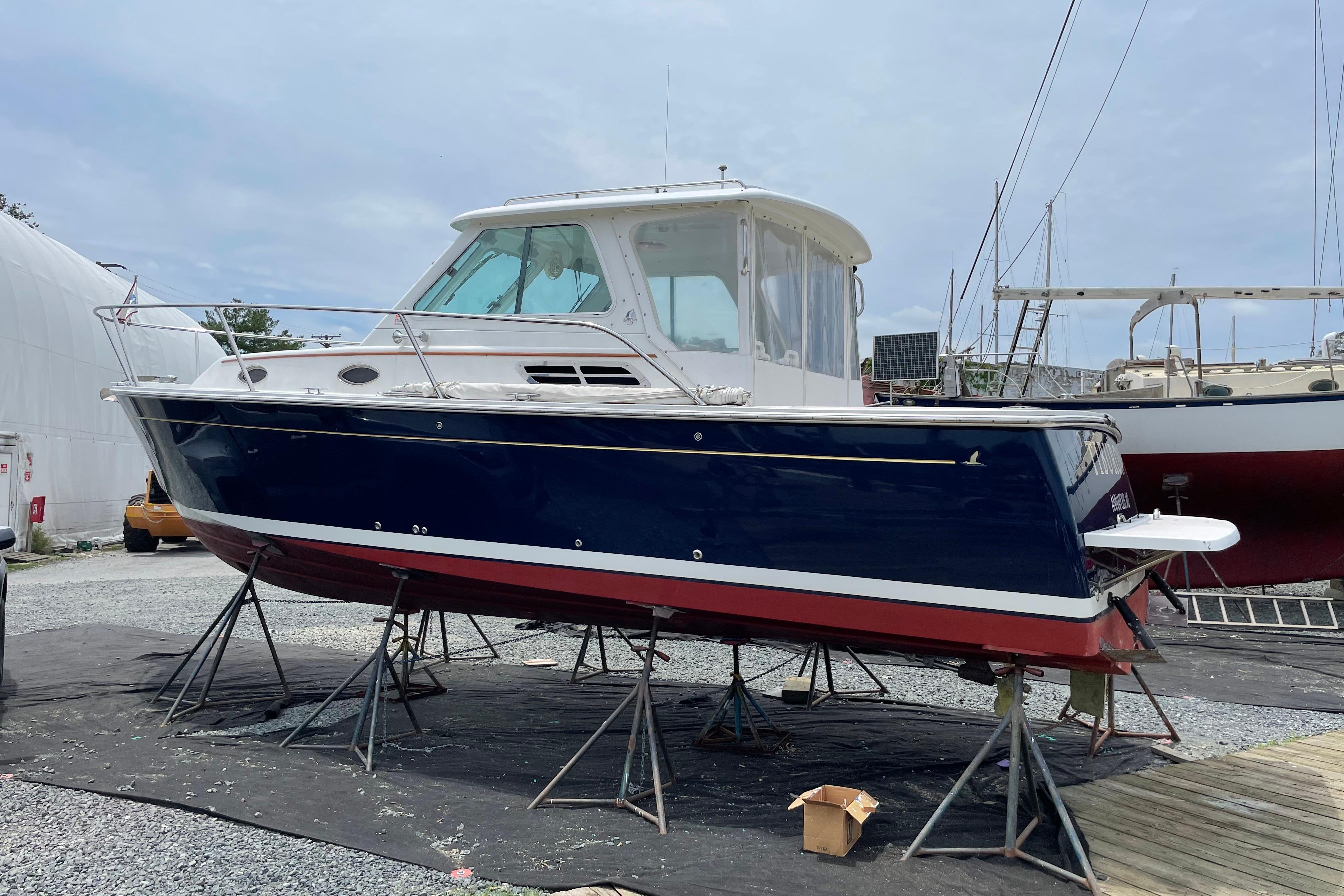 2007 Back Cove 29 boat on stands, blue hull, white cabin, outdoor setting.