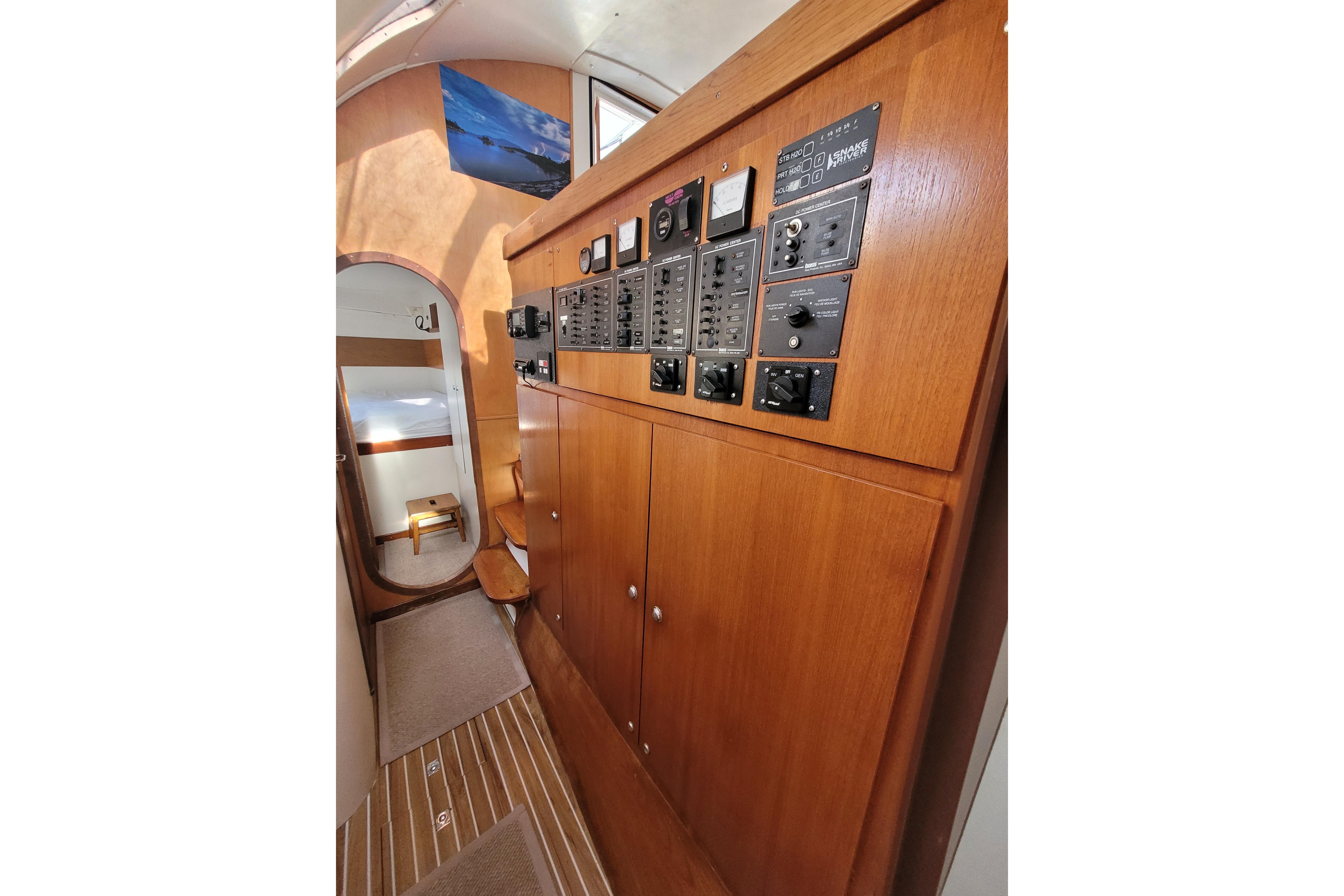 Interior of 1995 Lagoon TPI yacht with wooden paneling and control switches.