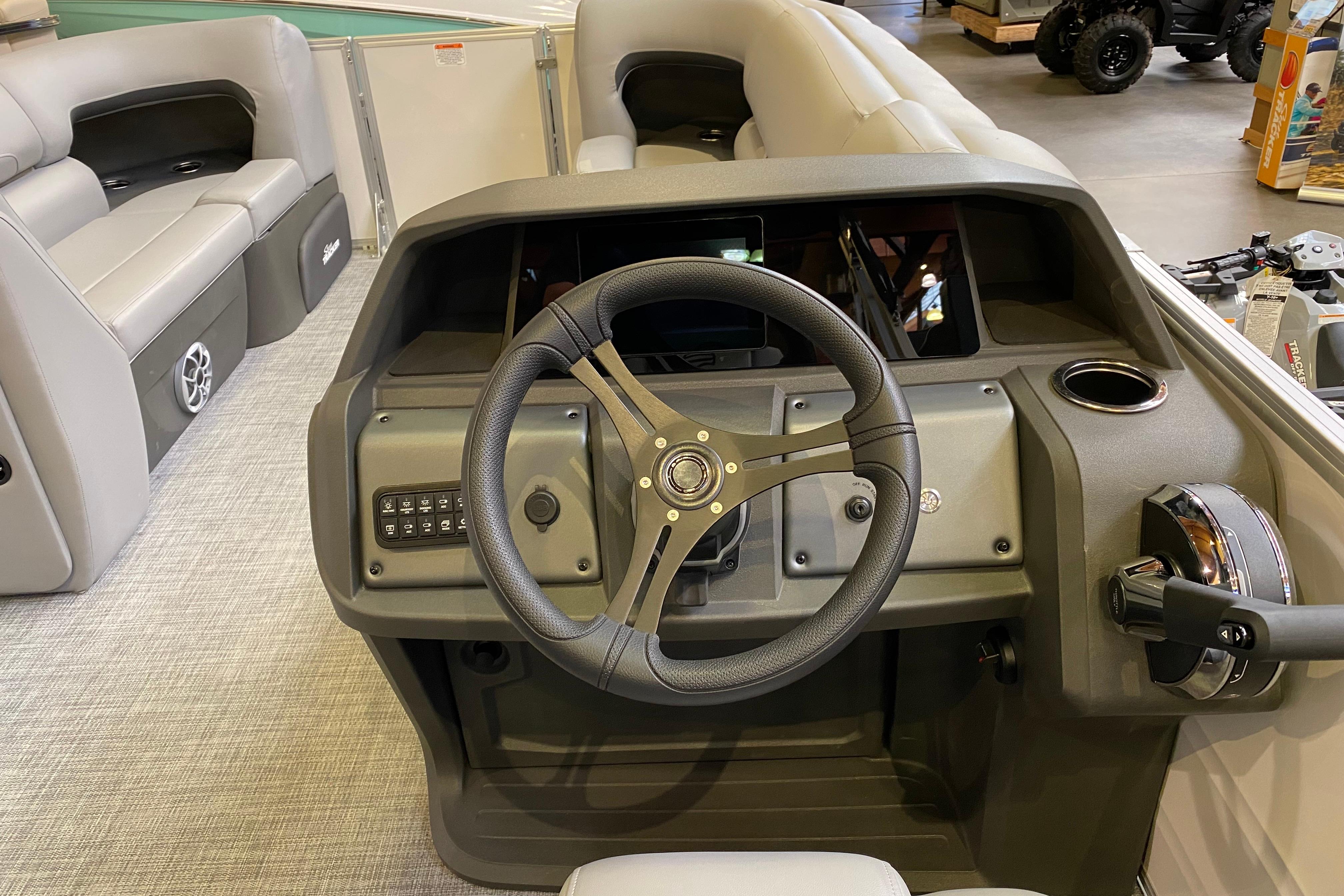 2026 Sun Tracker Party Barge 22 DLX helm with steering wheel and control panel.